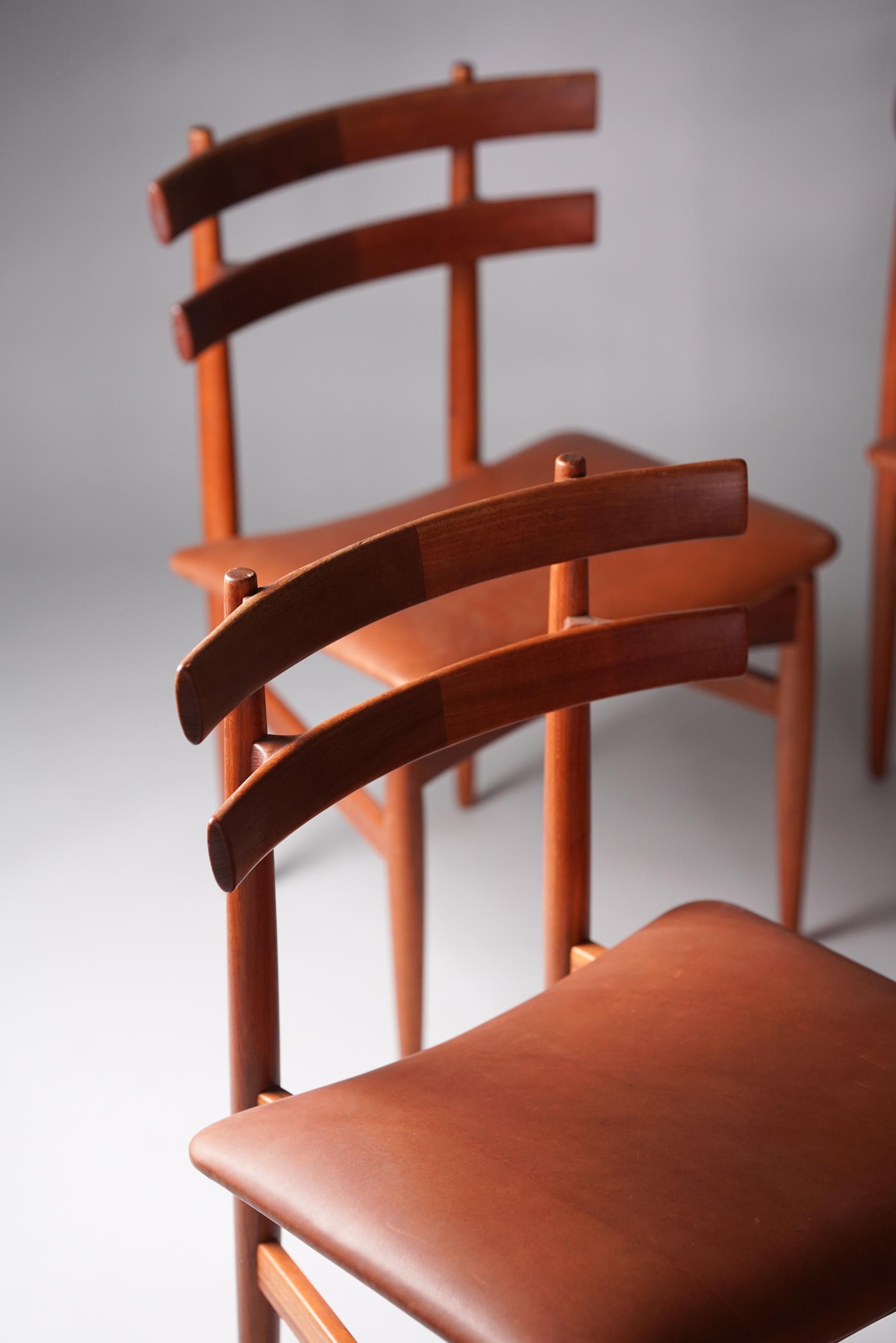 Set di quattro sedie per sala da pranzo, disegnate da Poul Hundevad, anni '60. Struttura in teak massiccio con seduta in pelle cognac. Ottime condizioni vintage, lieve patina coerente con l'età e l'uso. Le sedie sono vendute come set. Un bellissimo