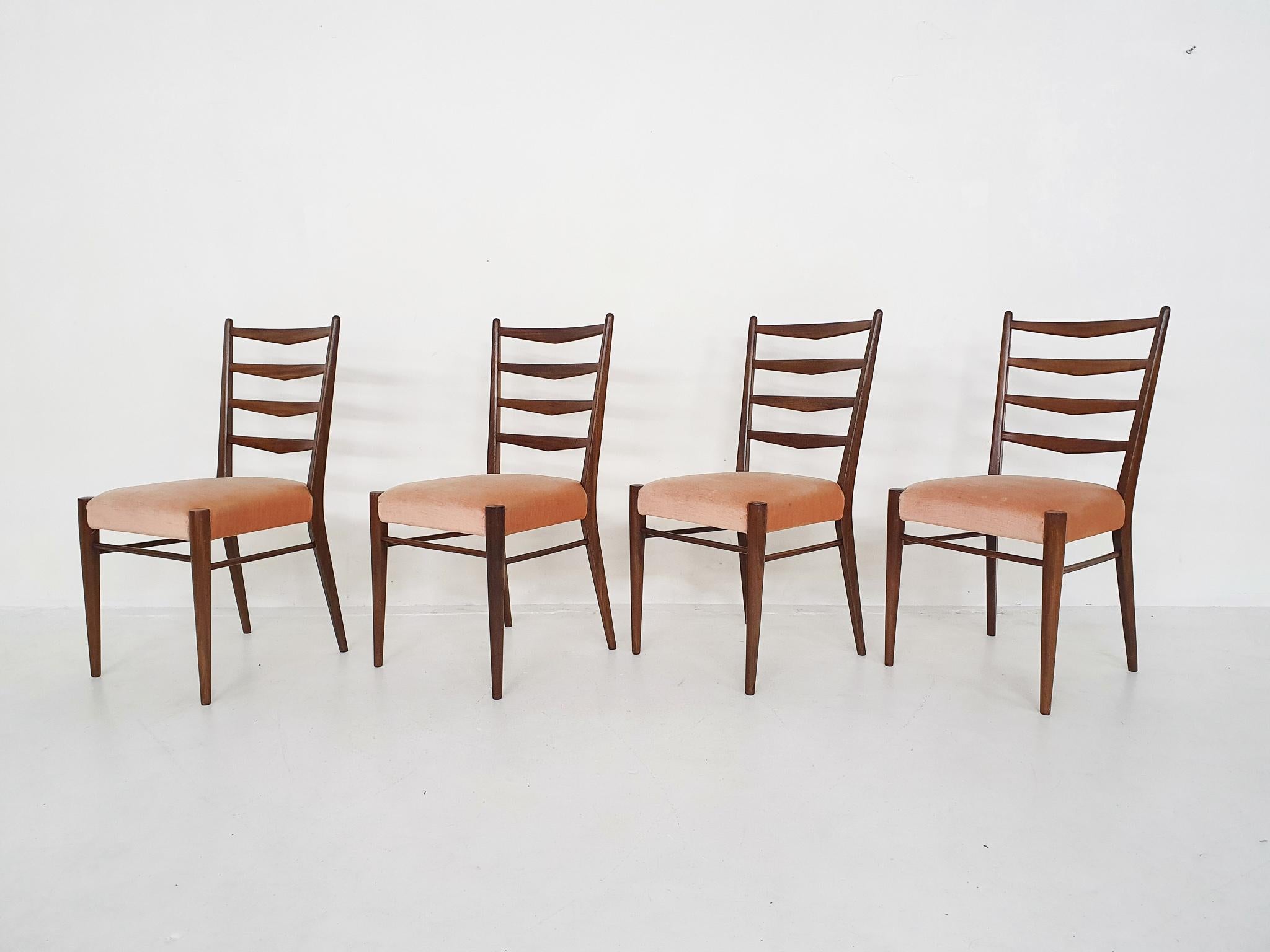 Four teak dining chairs with pink vlevet upholstery. The upholstery is a bit dis-colored. It is possible to have the chairs re-upholstered.
The teak frames are in good firm condition.
