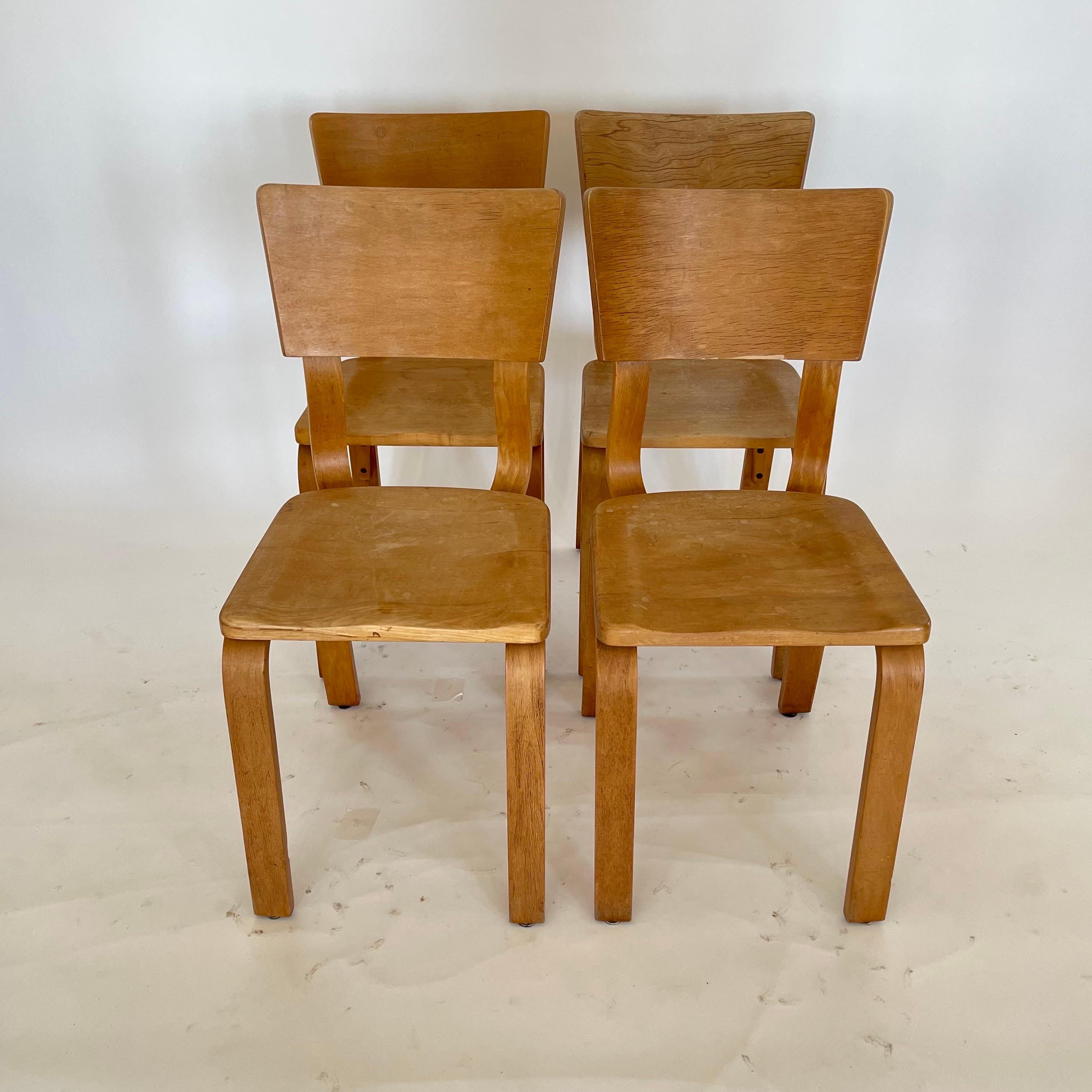 Set of four vintage Thonet 1216-S17-B1 dining or side chairs.  Rendered in steam bent oak plywood, with a beech sculpted saddle seat.  This set of chairs is in its original distressed vintage condition, circa 1940s.