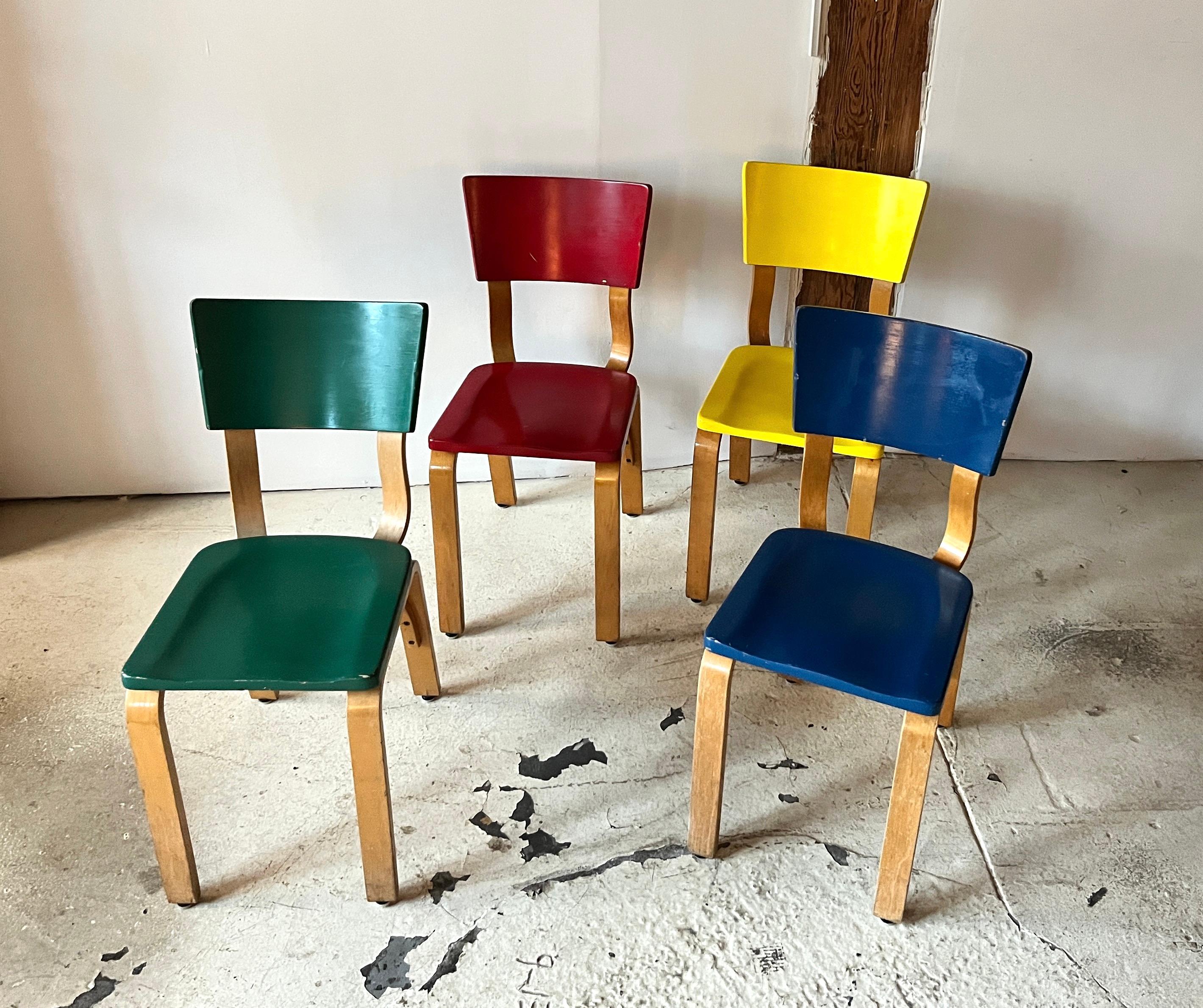 Set of four vintage Thonet 1216-S17-B1 dining or side chairs. Rendered in steam bent oak plywood, with a beech sculpted saddle seat. Circa 1940s

Unusual set with one each painted in the four primary colors of green, blue, red and yellow. 

This set