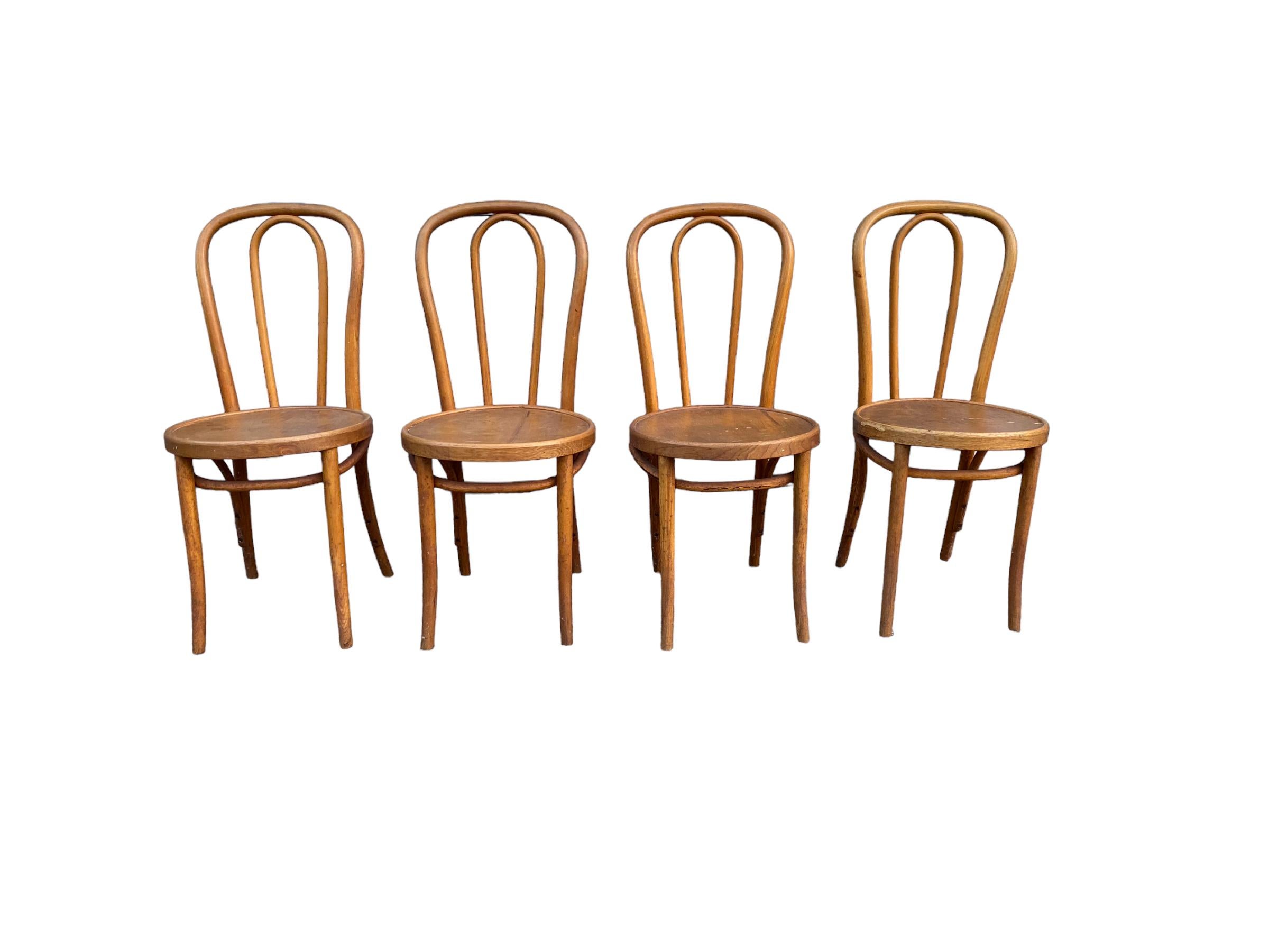 Set of Thonet Bentwood bistro chairs. This set of bentwood beech wood chairs feature curved back and legs with a solid circular seat in original honey brown finish. With beautiful patina and age, these chairs carry on the tradition and beauty of