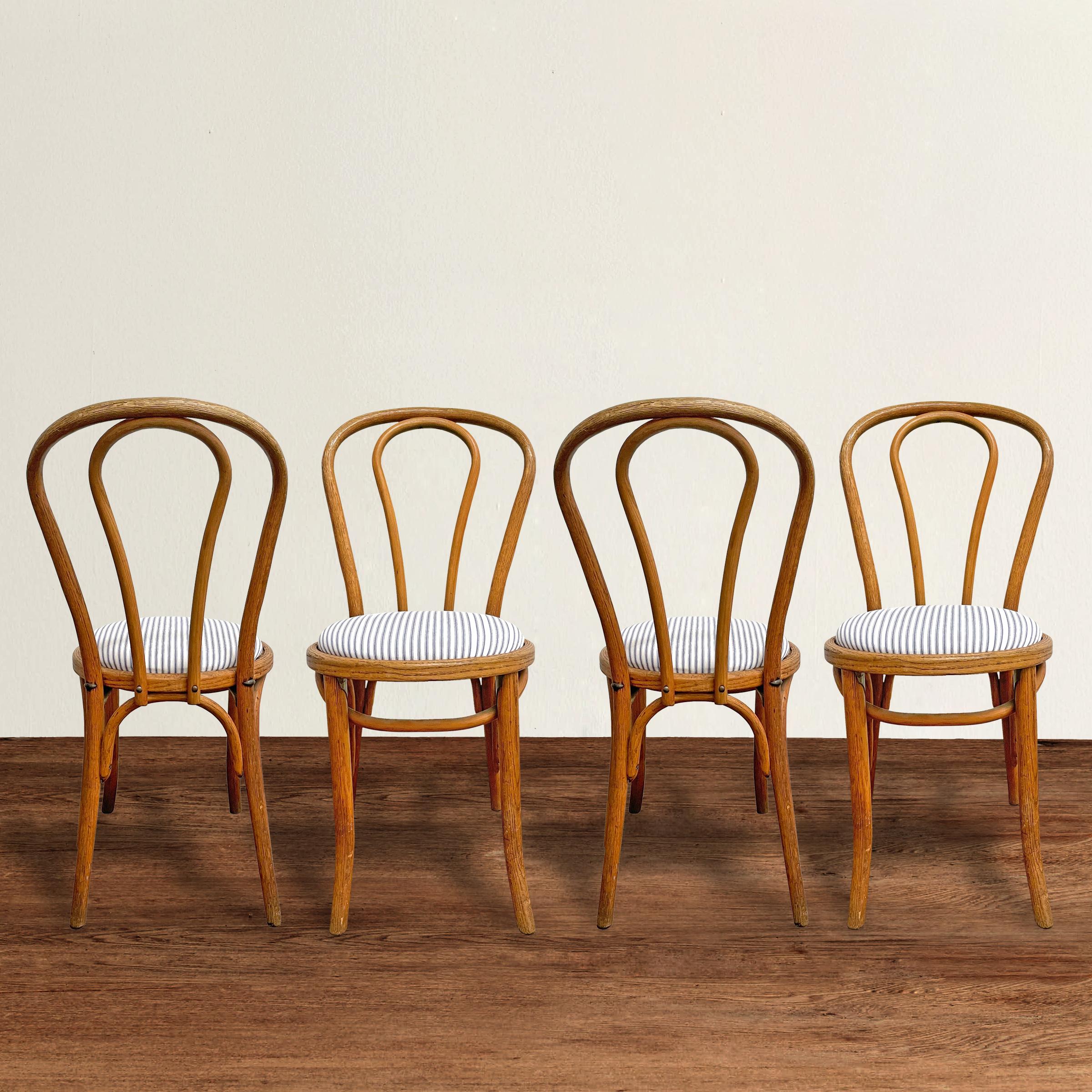 A charming set of four late 19th century Thonet no. 18 bentwood chairs, often referred to as the most successful chair designs ever, and newly upholstered in a French blue and white cotton ticking.