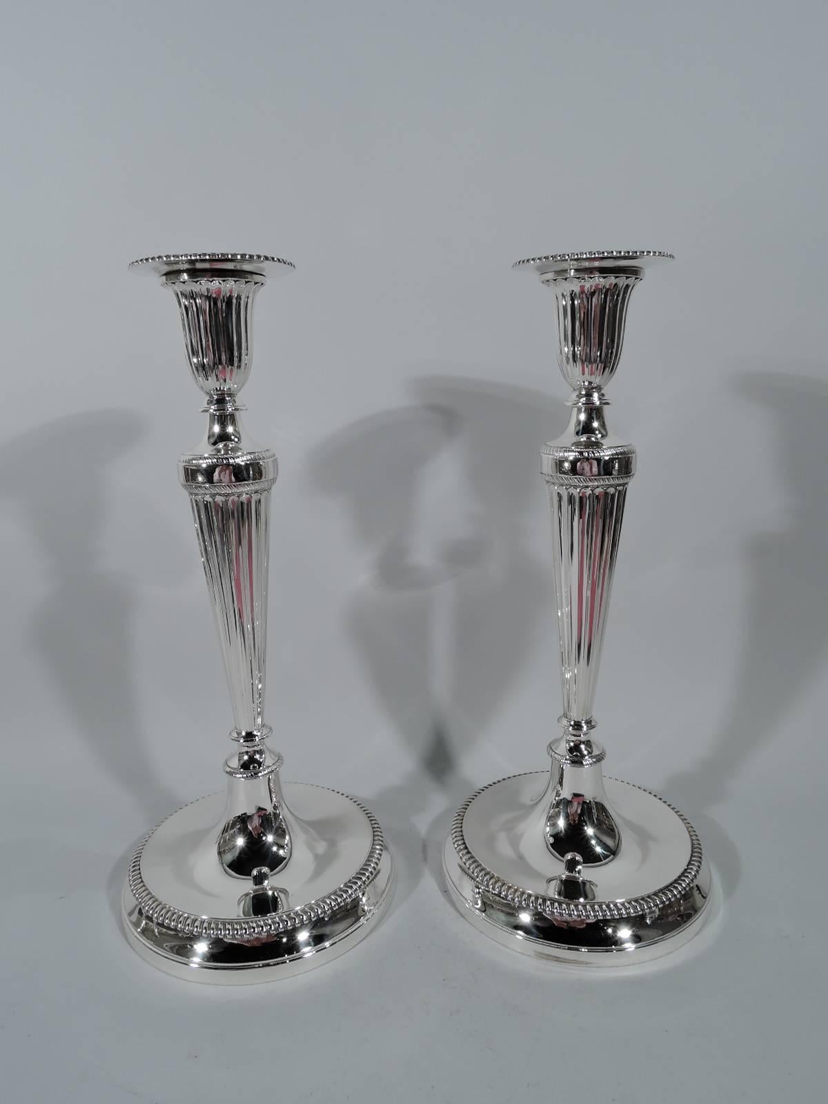 Set of four big and bold sterling silver candlesticks. Made by Tiffany & Co. in New York, circa 1917. Each: Fluted Classical column with same socket, detachable bobeche, and domed foot. Gadrooning and egg-and-dart ornament. Historic design that