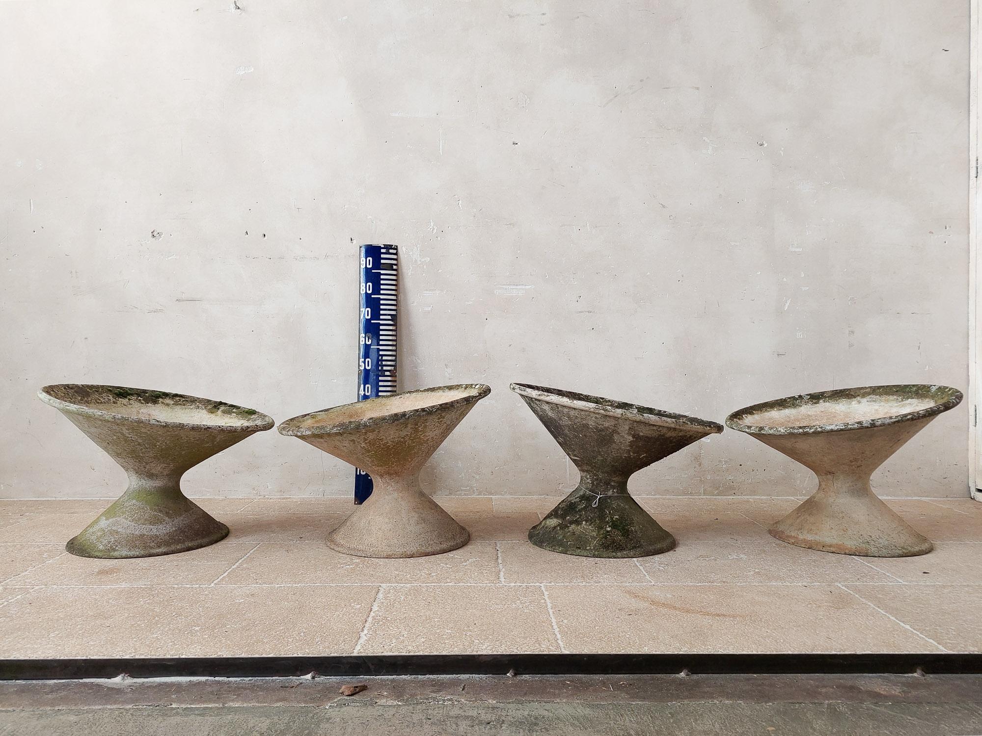 Set of four tilted concrete planters by the Swiss architect Willy Guhl. Manufactured by Eternit AG, who produced all of Guhl's designs. Made from fiber cement, the planters are lightweight and durable in all climates. These sculptural planters have