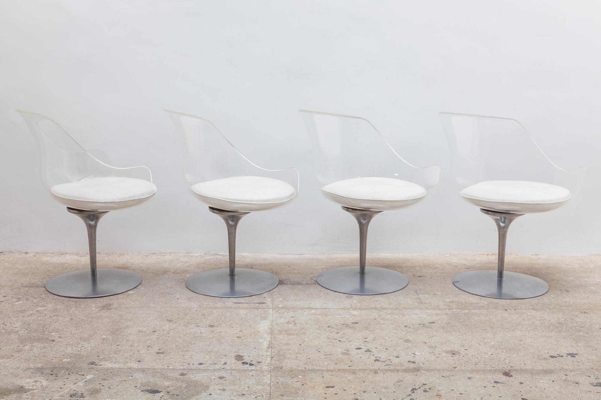 Vintage 1960s translucent Lucite bucket chairs. Tulip shaped polished cast aluminum base. Tufted white leather cushions attach with Velcro. The chairs can swivel and return to center. Dimensions: 60 W x 81 H x 60 D cm. Seat 46cm high. This set of