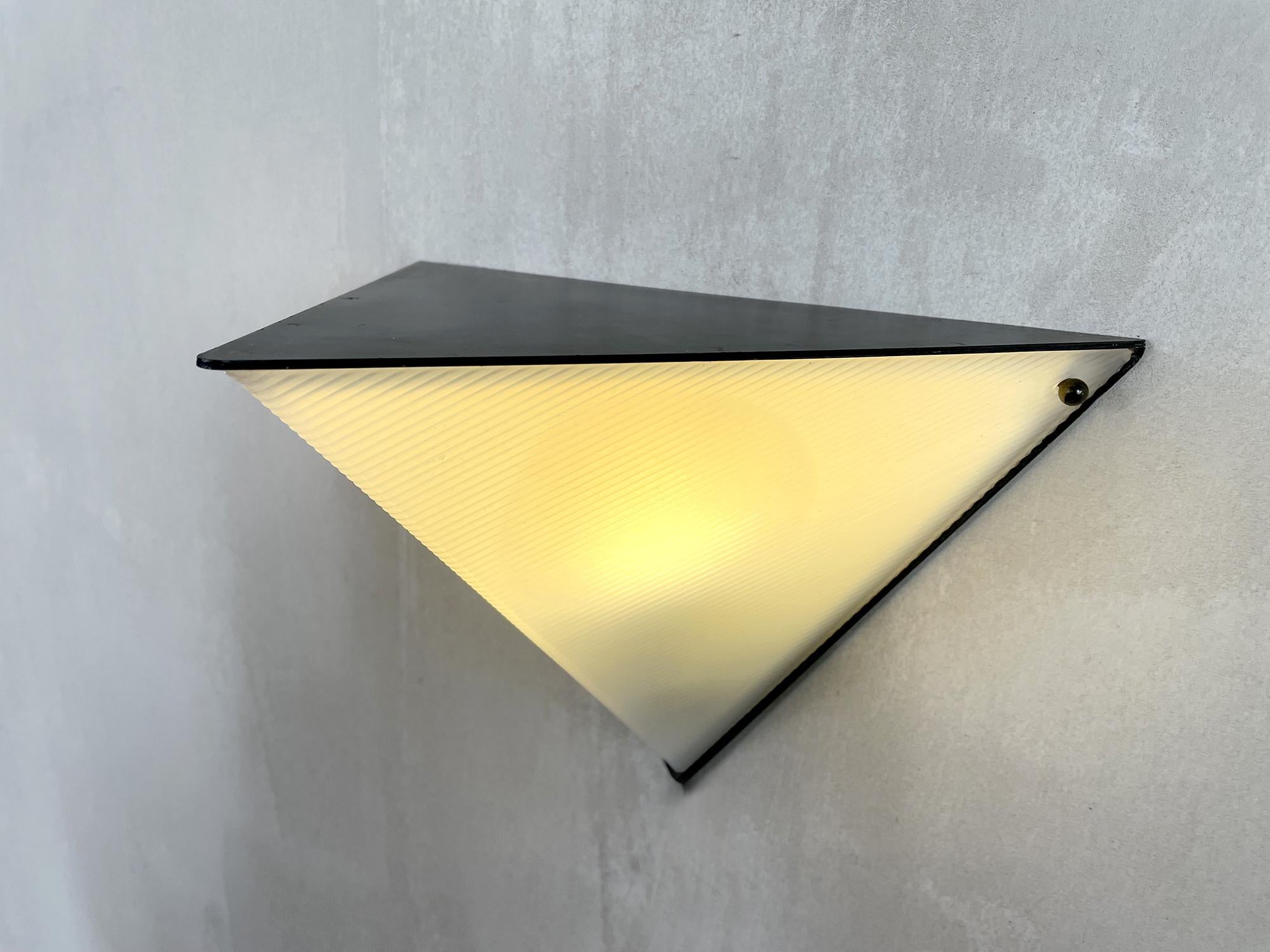 Set of four triangular wall lights in matte black lacquered metal, ribbed plastic diffuser, 1960. The light produced is very pleasant, by their shape these wall lights can be placed according to your wishes.
Very good manufacturing quality, in the