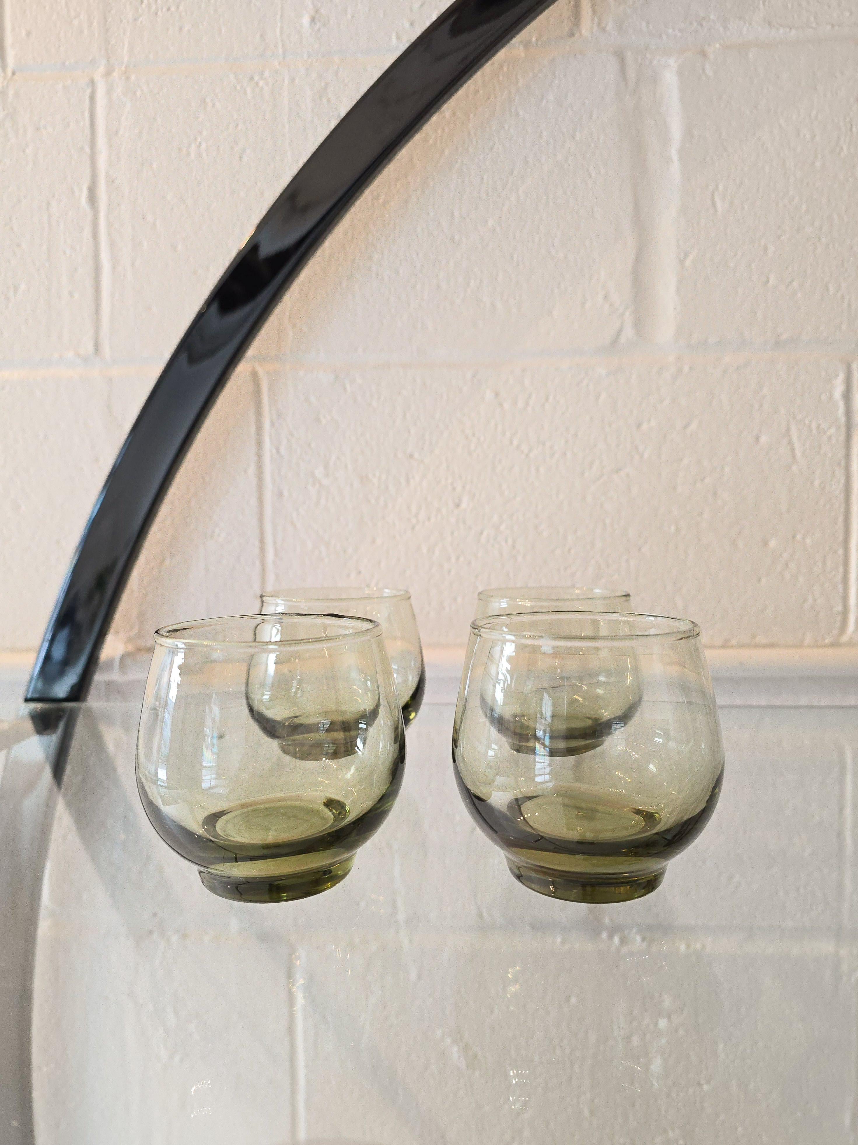 Set di quattro bicchieri tumbler da bar attribuiti a Libbey Glassware Co. Marcato sul fondo dei bicchieri. È realizzato in vetro di colore verde oliva. Può essere utilizzato per diverse bevande. Perfetto per l'uso quotidiano e per l'intrattenimento.