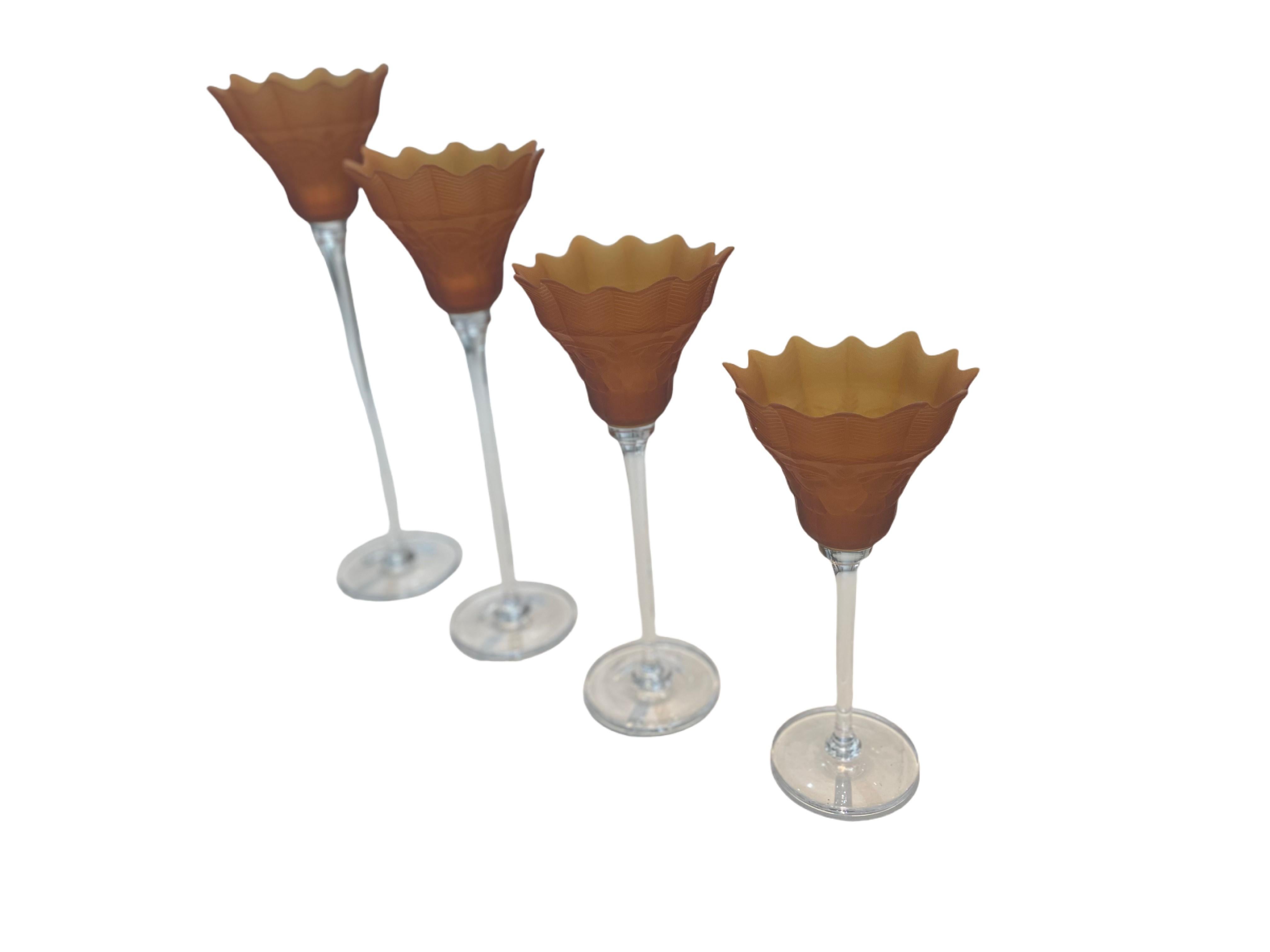 The frosted amber-colored floriform top of these vintage candleholders contrast beautifully with the set’s clear glass stem and base. All measure 6.25 inches in diameter (top and base), while they vary in height: 19.5”; 17.25”; 15”; 13” - adding