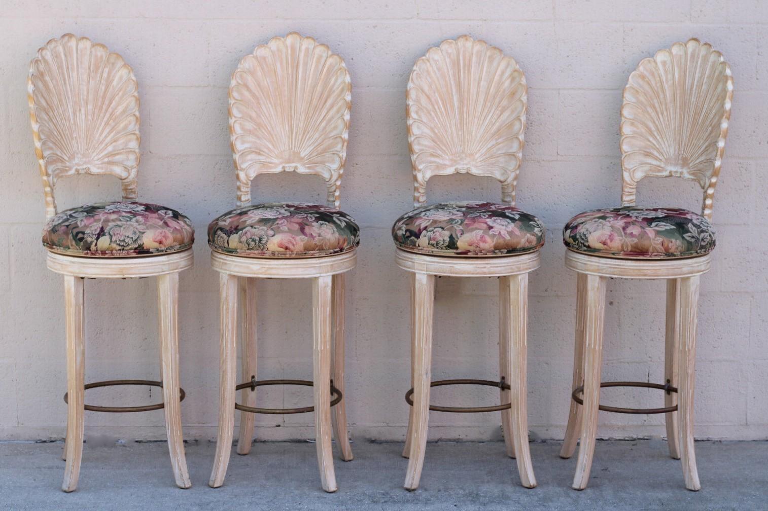 Vintage set of four beautiful Italian bar stools featuring a scalloped shell back in the Venetian grotto style. Quality of craftsmanship is evident in this set of swivel bar stools with as found vintage upholstered seats. The carved wood has a
