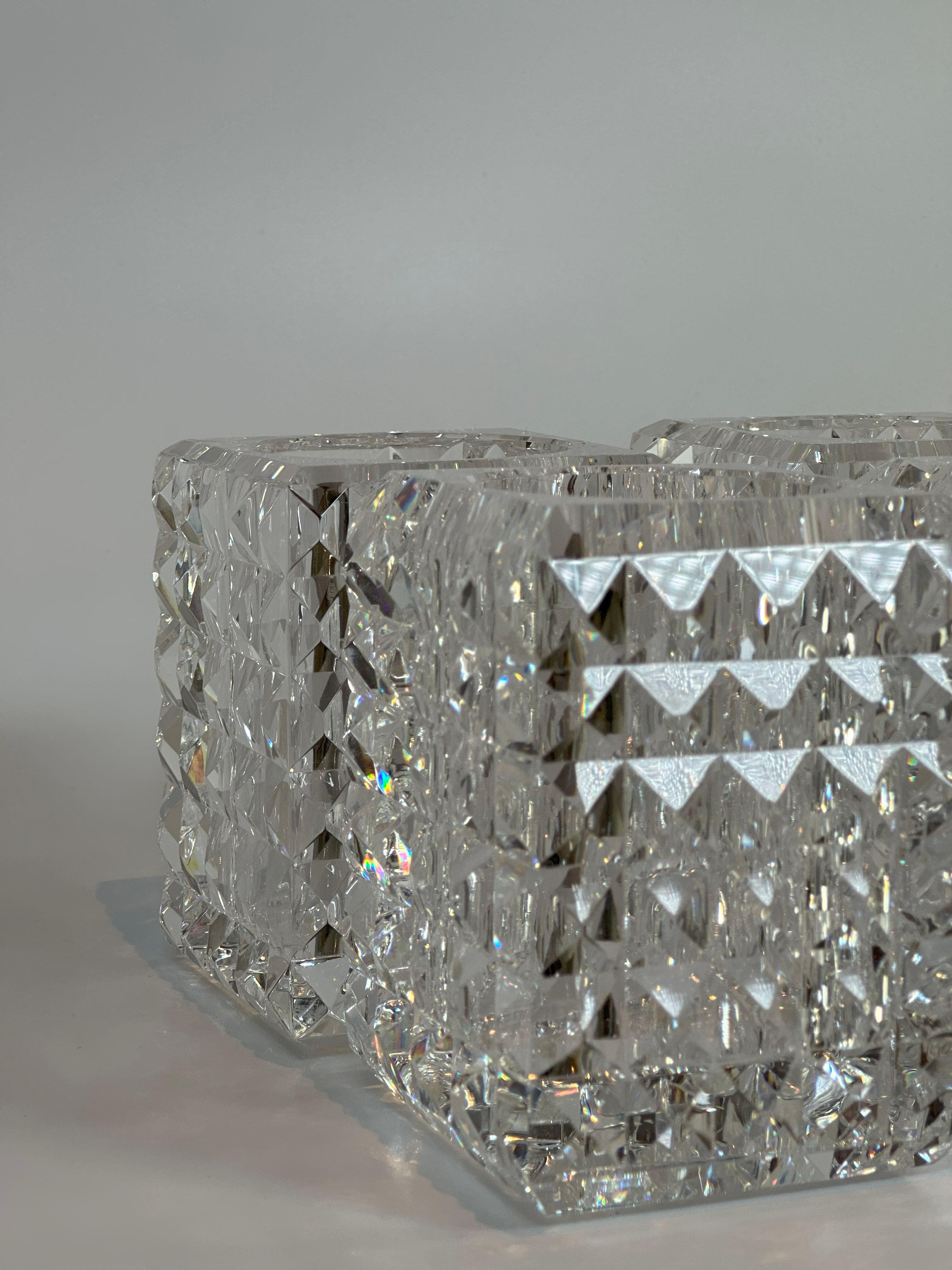 Set of four contemporary faceted optical glass candle votives by Veritas, Texas, 2016. Each votive is hand-crafted from crystal-clear optical glass in a compact square form, precision-cut with a grid of pyramidal facets on all sides. When lit, the