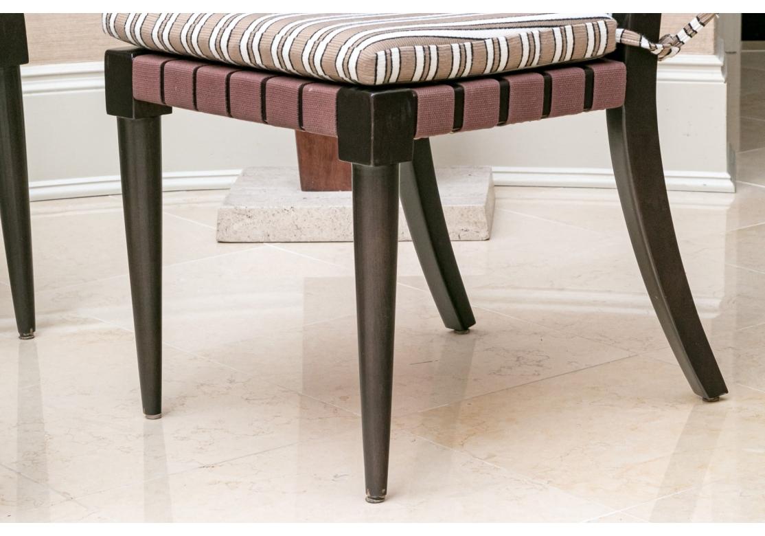 A st of four well made and classic Modern Klismos chairs from Neidermeier. Having ebonized wood frames with square backs and raised on tapering cylindrical front legs and square splayed back legs. Constructed with brown fabric webbing for the seats