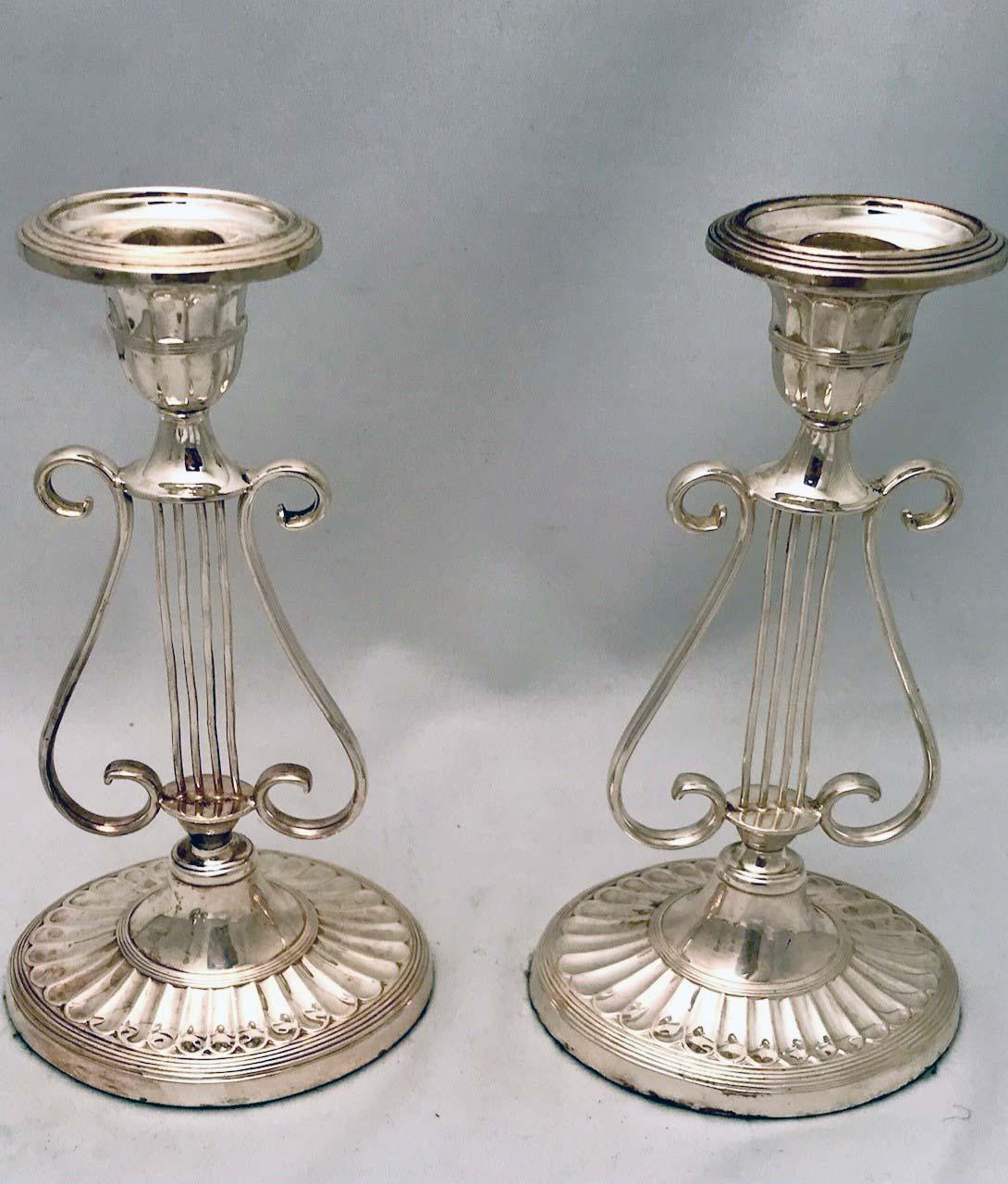 These are on weighted scalloped oval bases, rising to a lyre-shaped stem supporting  oval candle.-cups. It is unusual to find a set of four in such good    condition.
They would grace any table, particularly that of musicians or those who like the