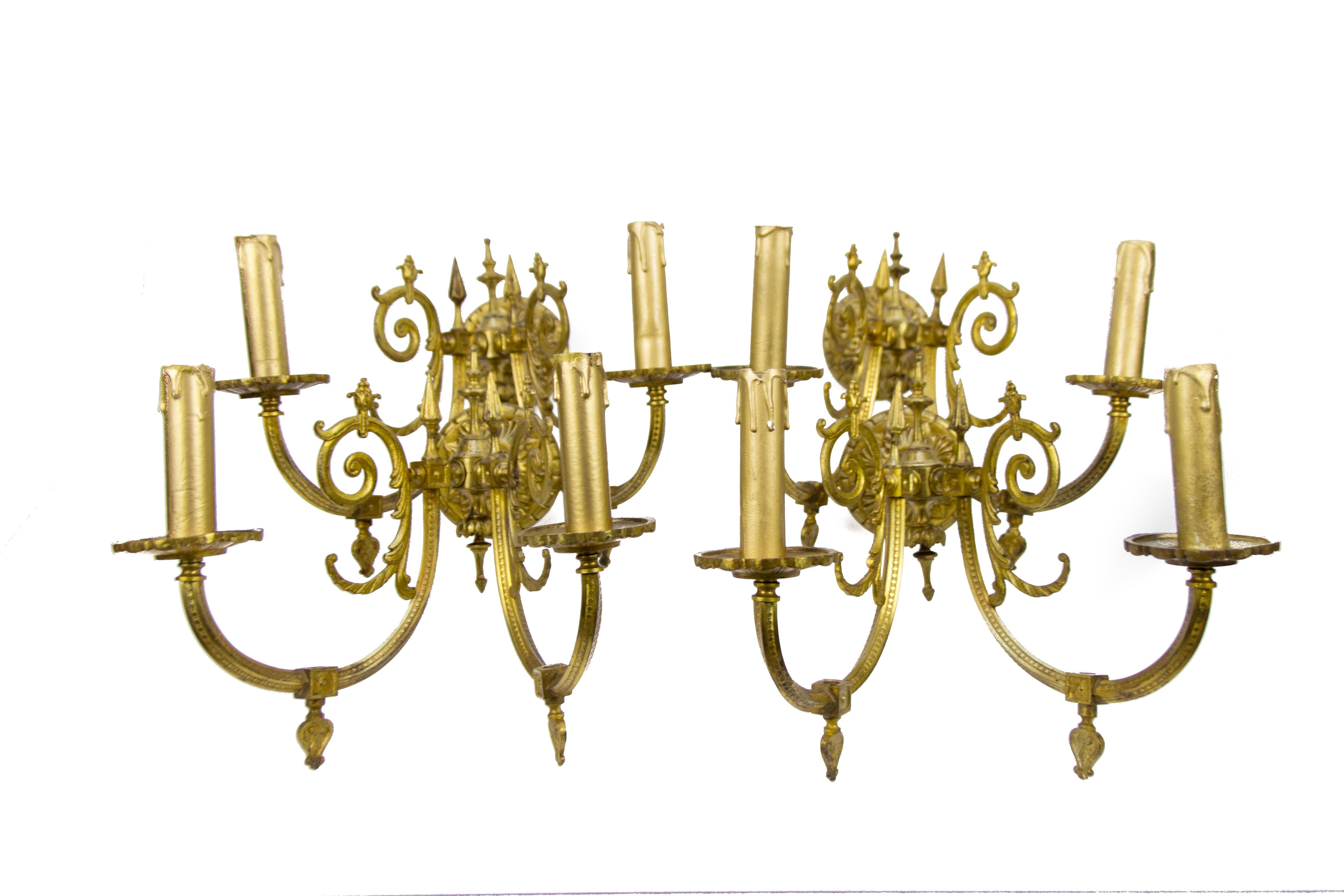 Satz von vier bronzefarbenen Wandleuchtern im viktorianischen Stil, die mit Gas betrieben werden und aus dem späten 19. Jahrhundert stammen. Jede Leuchte hat zwei Arme aus Bronze und jeder Arm hat eine Fassung für eine Glühbirne der Größe E 14.
