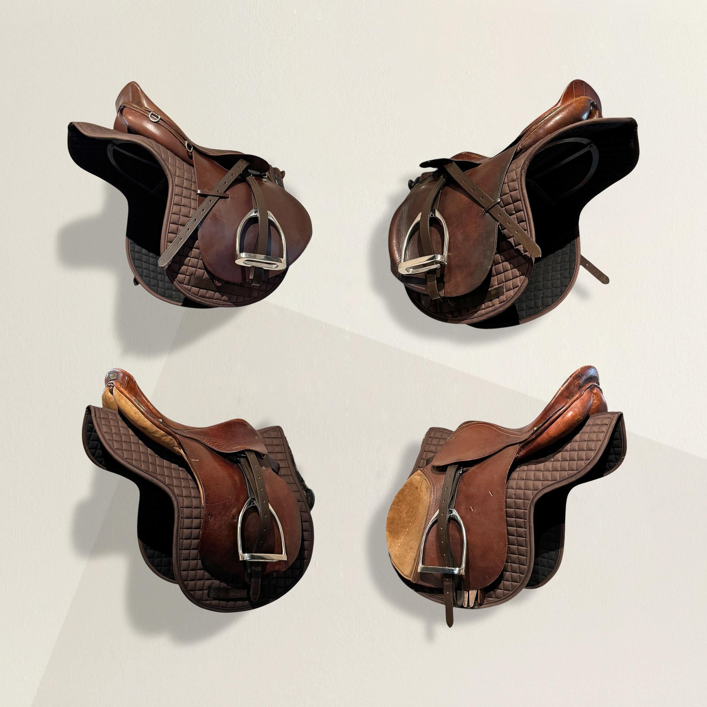 Questo set di quattro selle vintage American English, o Jump, conferisce un autentico carattere equestre a qualsiasi ambiente interno o di scuderia. Realizzata in ricca pelle marrone e proveniente da un allevamento di cavalli da lavoro nell'Illinois