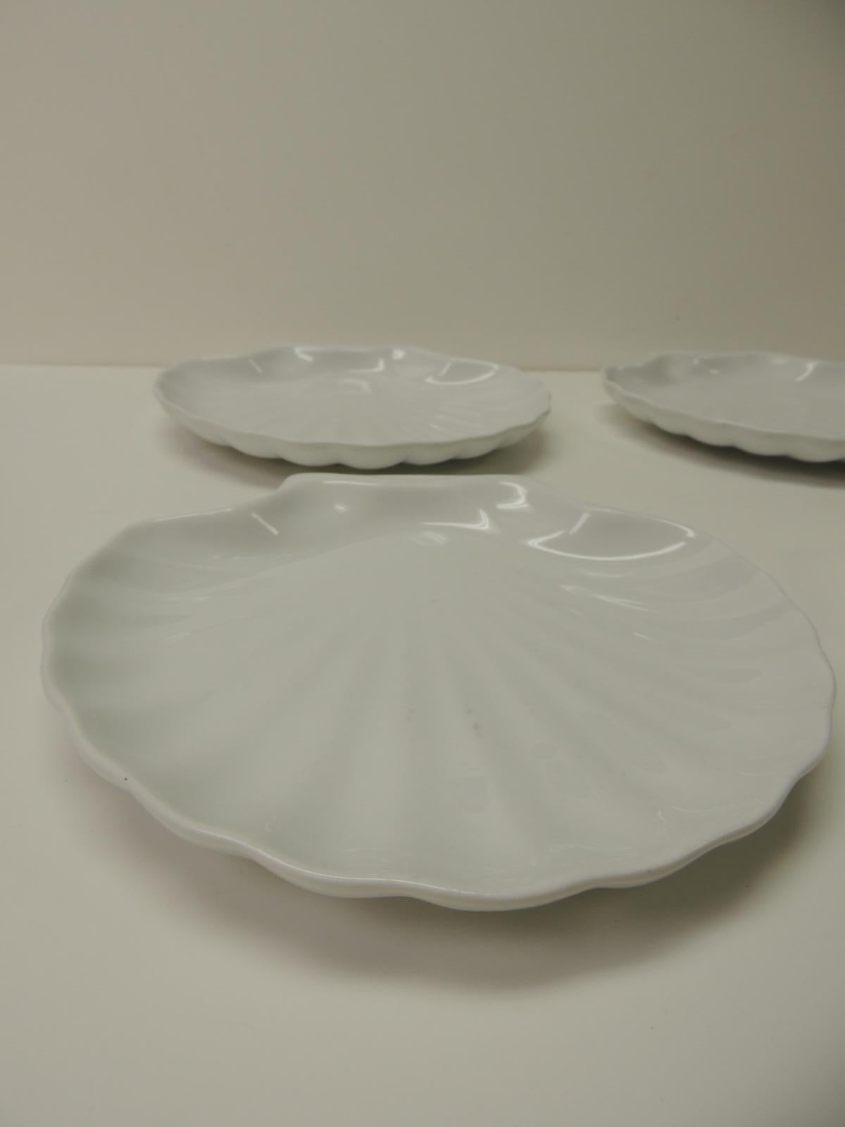 Set of four vintage coastal scallop seashell shaped plates
Set of four white ceramic scallop seashell shaped plates. 
Porcelain made 1980s, France.
Size: 9 x 10 x 1

 