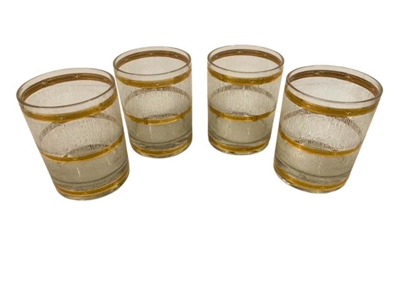 Set of 4 mid-century modern rocks glasses by Culver in the Icicle pattern with 2 wide bands of vertical frosted clear textured enamel between three 22 karat gold bands. The textured finish creates a non-slip and optical surface.