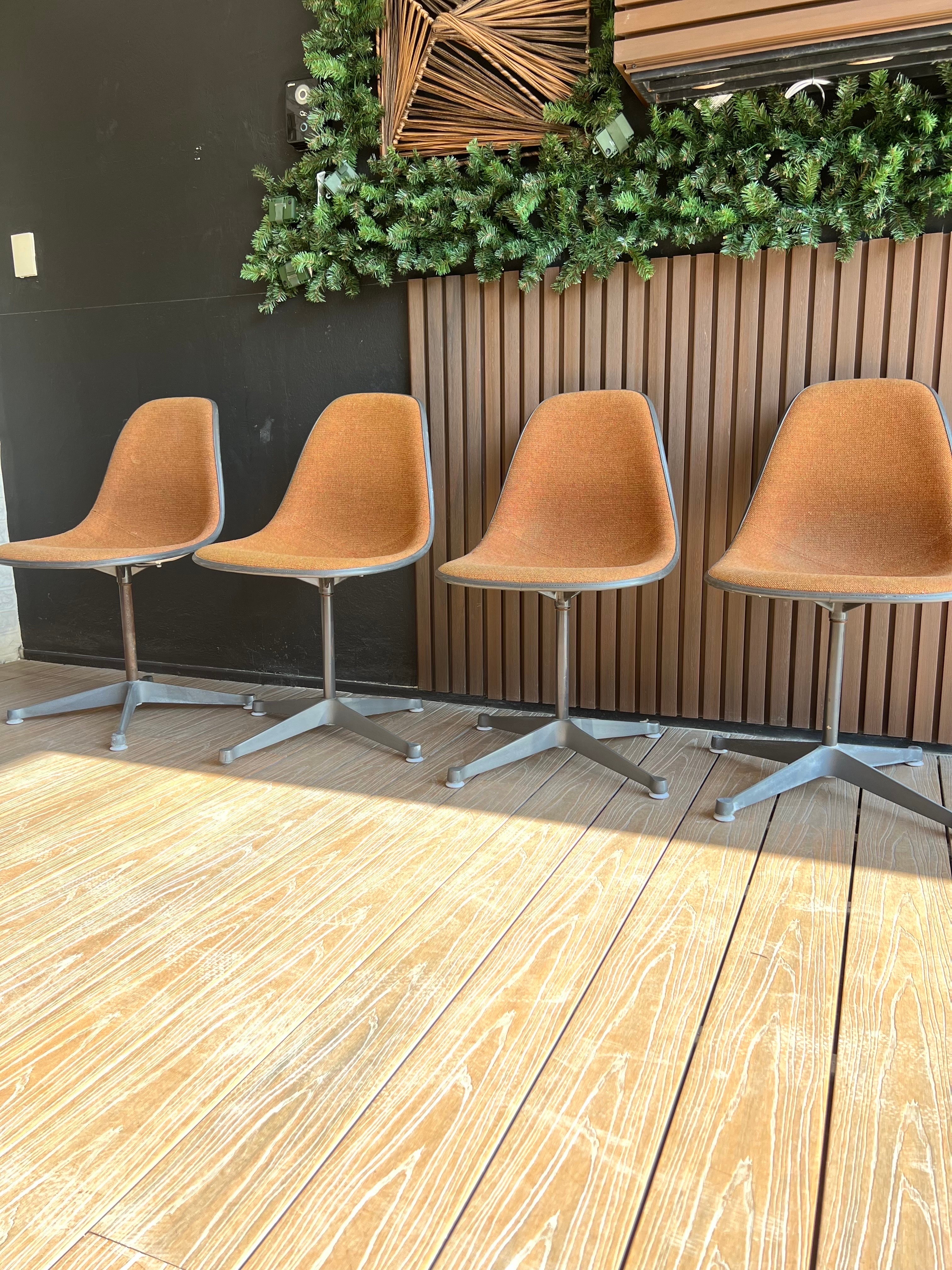 Set of four Eames chairs contractor swivel base for Herman Miller in their original condition, the fabric is a little discolored in some but it is the original, one chair is missing the plastic on one of its legs, the metal looks a little rusty, all