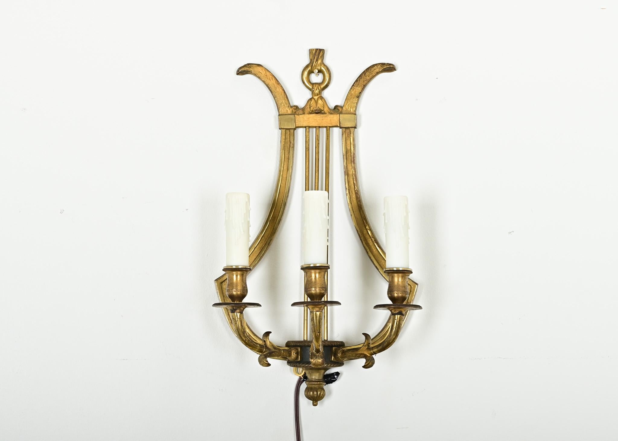 Questo set di quattro applique francesi vintage del XX secolo è ricco di dettagli storici che fanno riferimento ai temi del Direttorio e del Neoclassico. Fusi in ottone pesante e di alta qualità, sono di una scala e di un materiale bellissimi, che