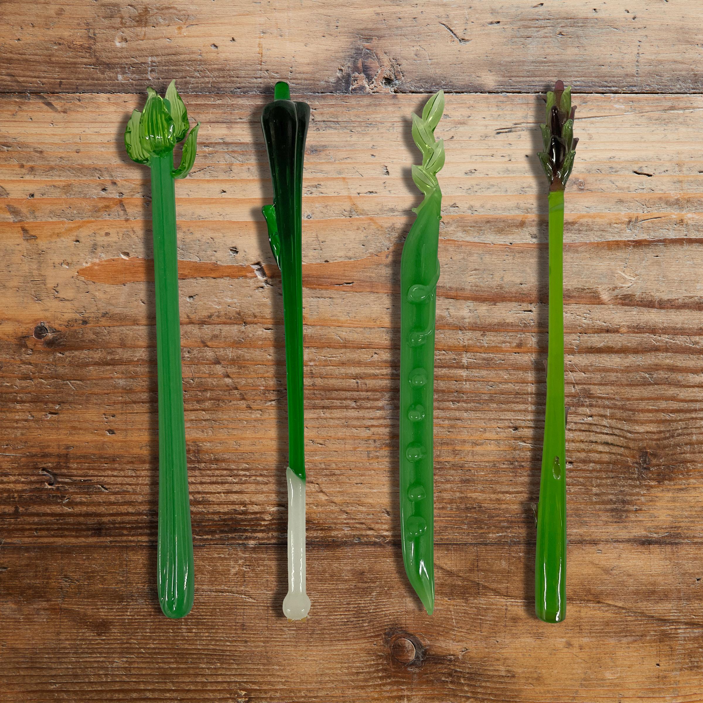 A cheeky set of four vintage hand-blown glass Bloody Mary swizzle sticks depicting four vegetables, a celery rib, a green onion, a snow pea pod, and an asparagus stalk, waiting for your next hair-of-the-dog indulgence.