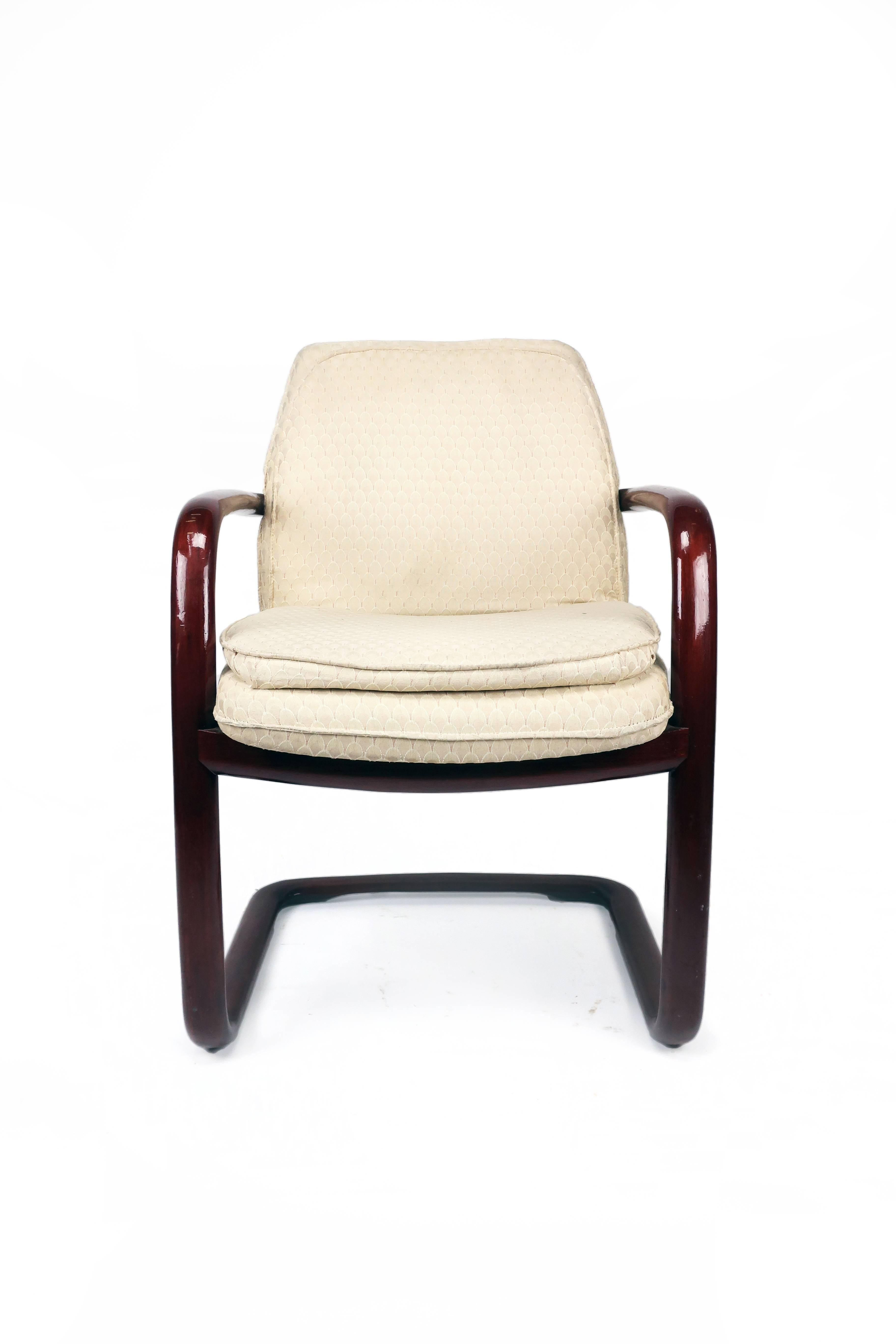 From the 1980s, this set of four vintage Gunlocke armchairs have a rich reddish wood frame and cream upholstered seats with an Art Deco inspired patter. The cantilever design is comfortable and visually striking.

Inset metal Gunlocke mark appears