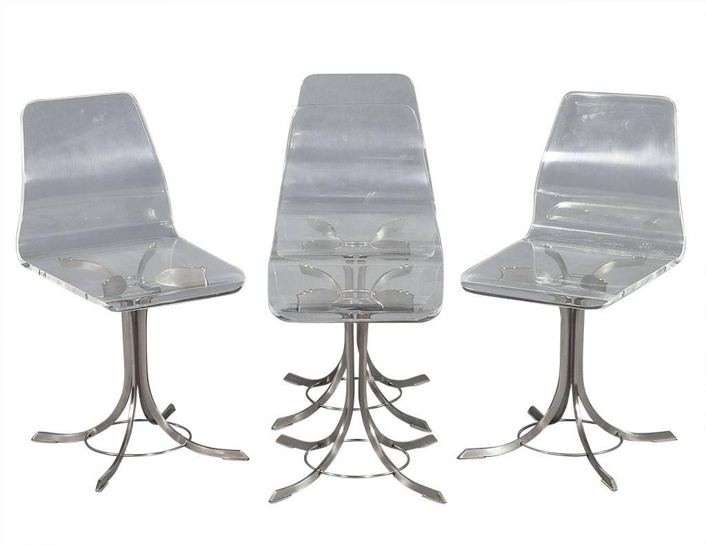 This set of four acrylic and chrome chairs are the epitome of Mid-Century Modern. The sleek waterfall Acrylic design makes for a simple and clean look. The chrome bases have a beautiful distressed rusted patina which is perfect for an Industrial or
