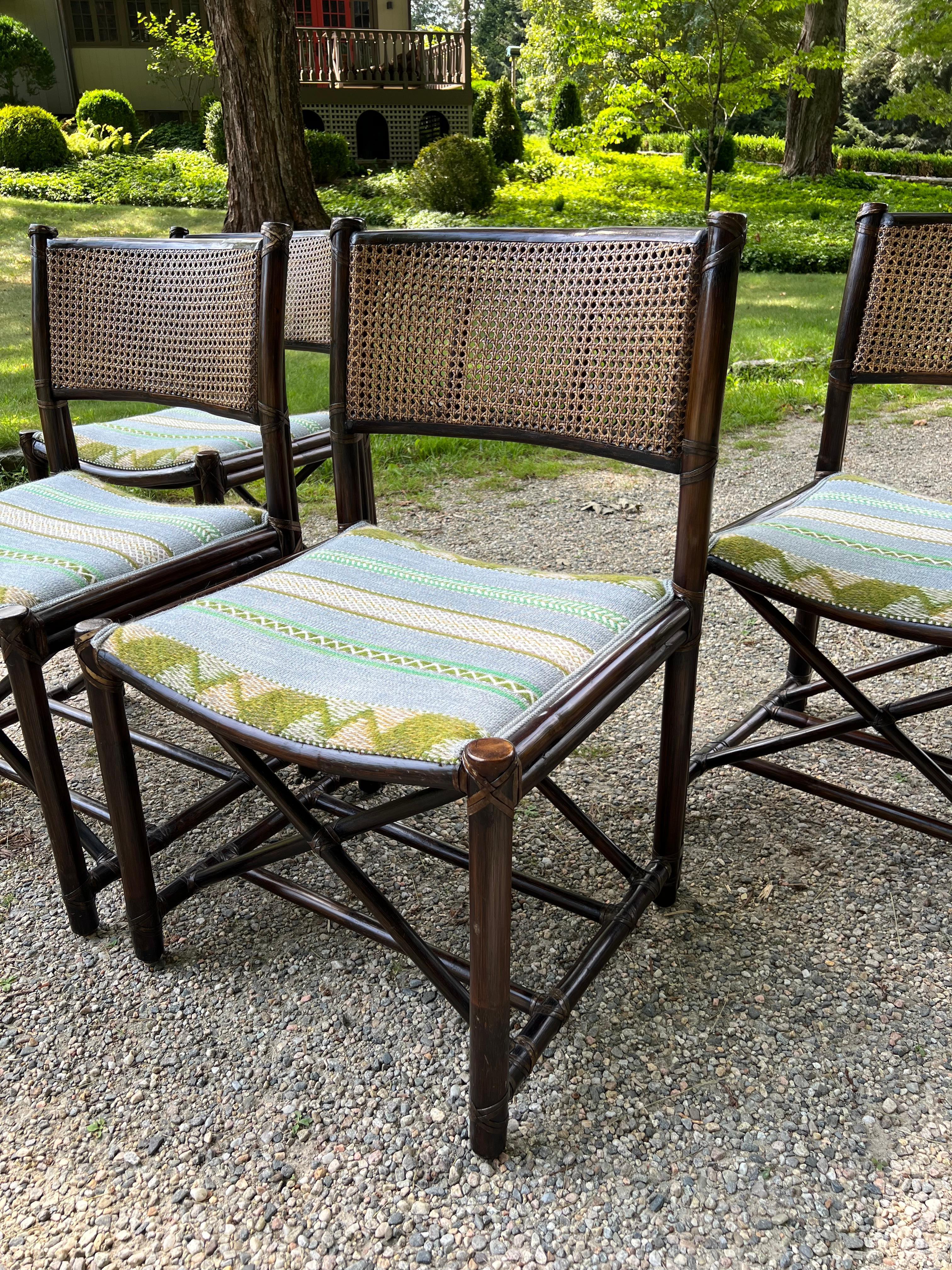 A striking set of four vintage dining chairs by McGuire Furniture, crafted in California in the 1970s. Each chair features the brand’s signature bent rattan frames with hand-lashed rawhide joints and a distinctive X-stretcher base — a hallmark of