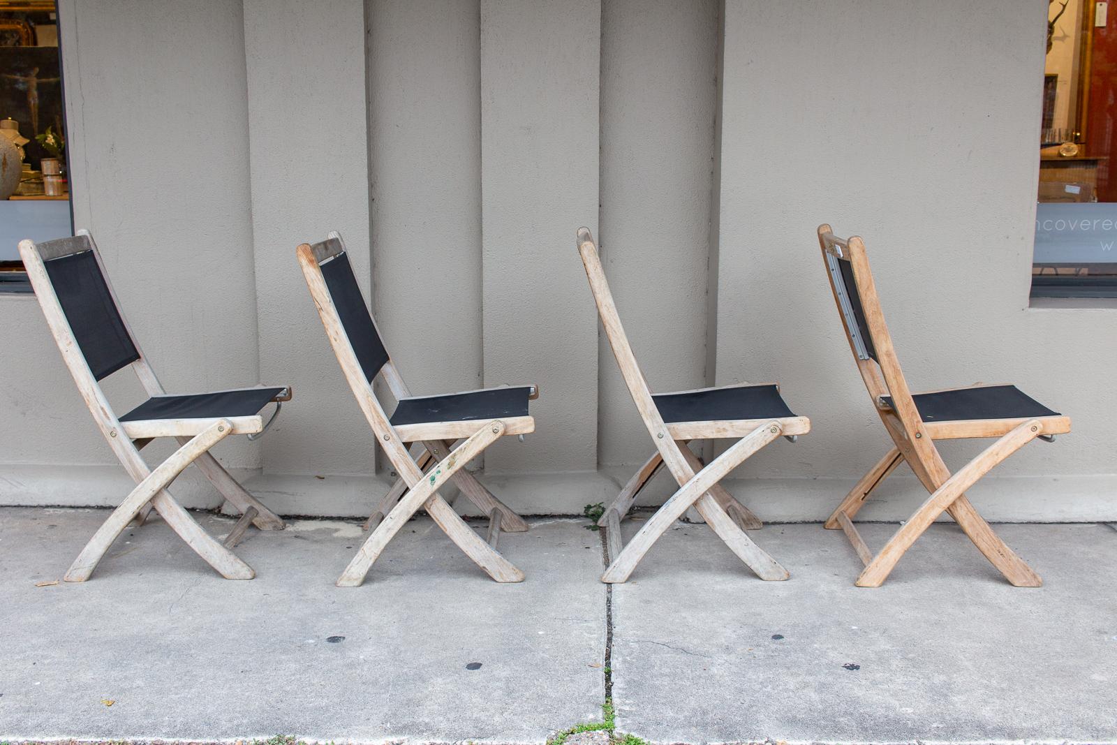 A set of four folding chairs crafted with teak, aluminum, and nylon mesh. These chairs are lightweight and easy to carry, yet quite sturdy and attractive. The nylon mesh back and seat are quite durable, while the teak has aged to a beautiful gray