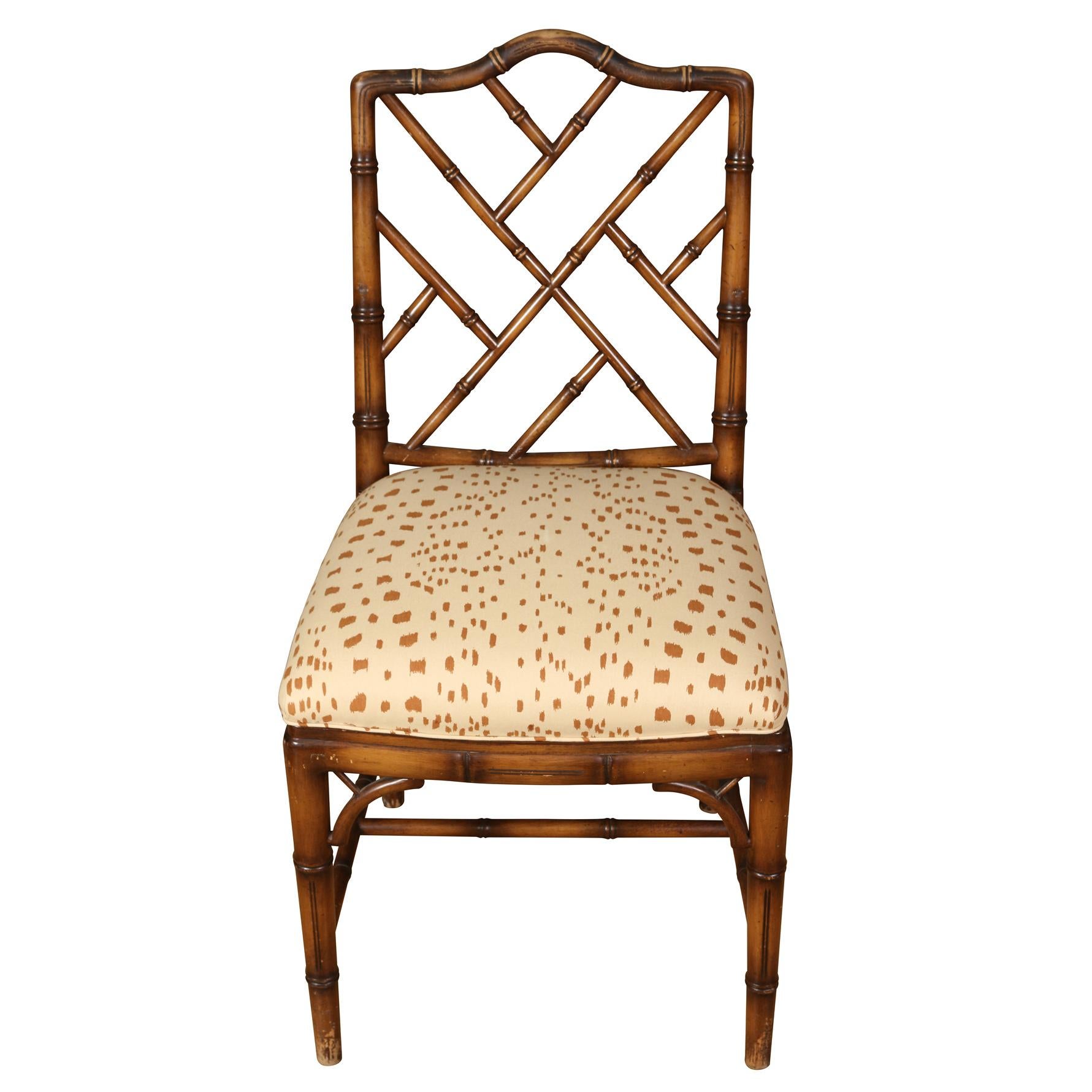 Un ensemble de quatre chaises vintage en bambou Yale By, nouvellement recouvertes de tissu Brunschwig & Fils les touches. Les chaises ont un dossier avec un motif Chippendale ajouré. Le tissu les touches est une teinte crème et marron qui complète