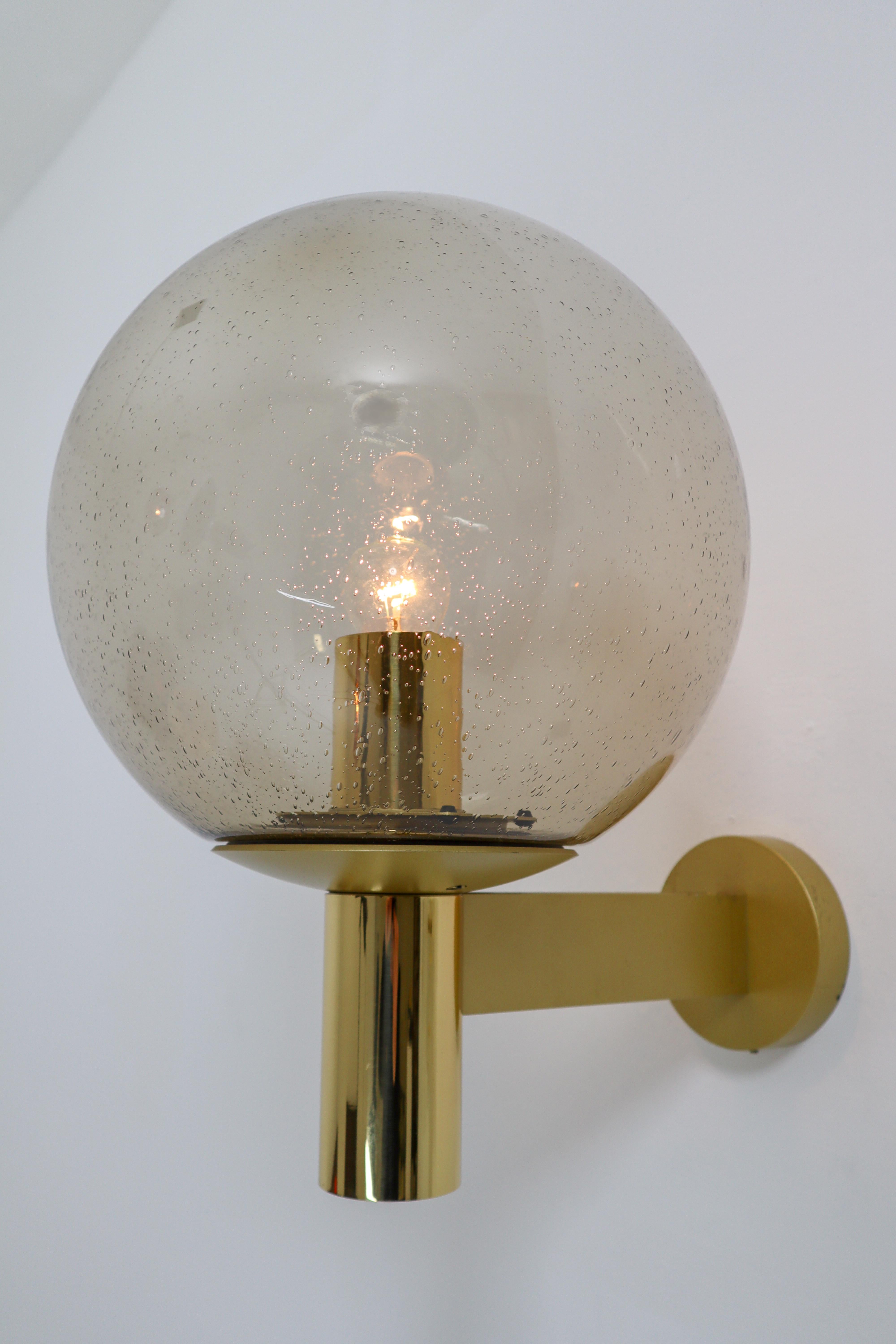 Set of four wall lights with smoked glass and brass by Glashütte Limburg, Germany, 1970s. The pleasant light it spreads is very atmospheric, these wall scones will contribute to a luxurious character of the (hotel-bar) interior. Good original