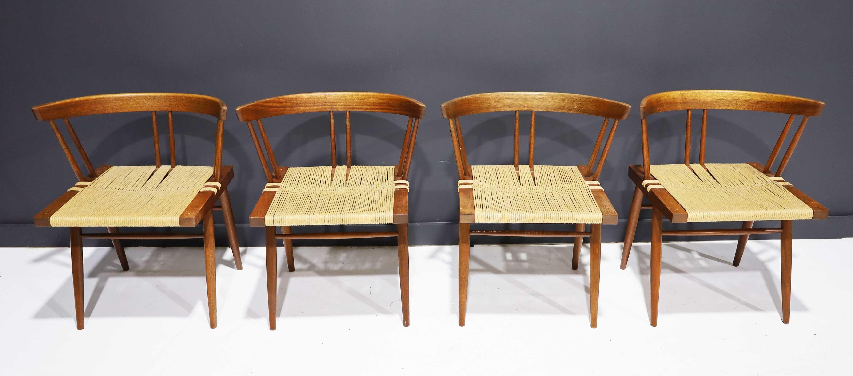 Set of 4 walnut grass-seat chairs, designed by George Nakashima and manufactured by George Nakashima. Includes original paperwork.