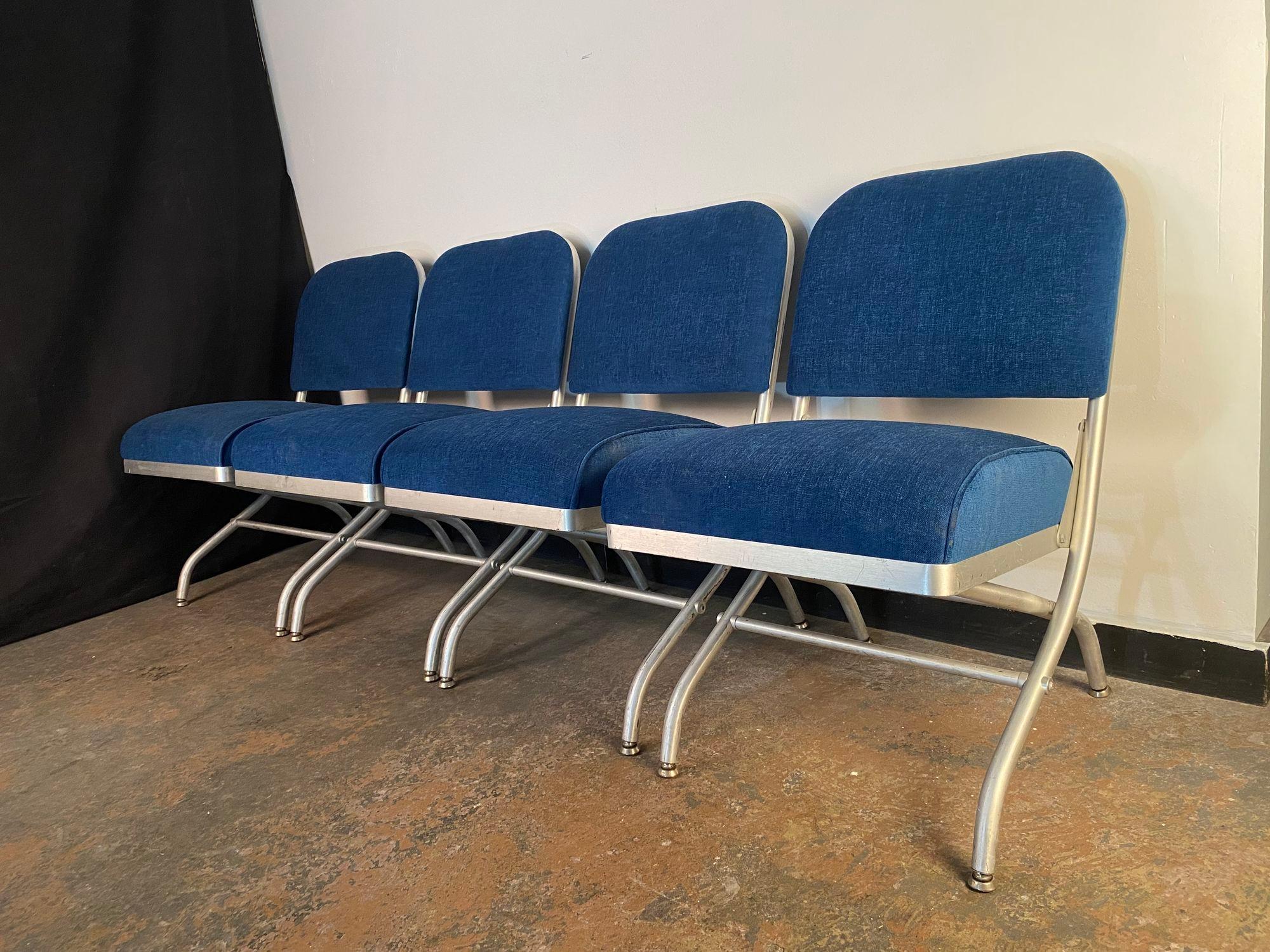 A set of four Warren McArthur in original brushed Aluminum with freshly reupholstered cushions in rich Blue velvet. A beautiful set of chairs.