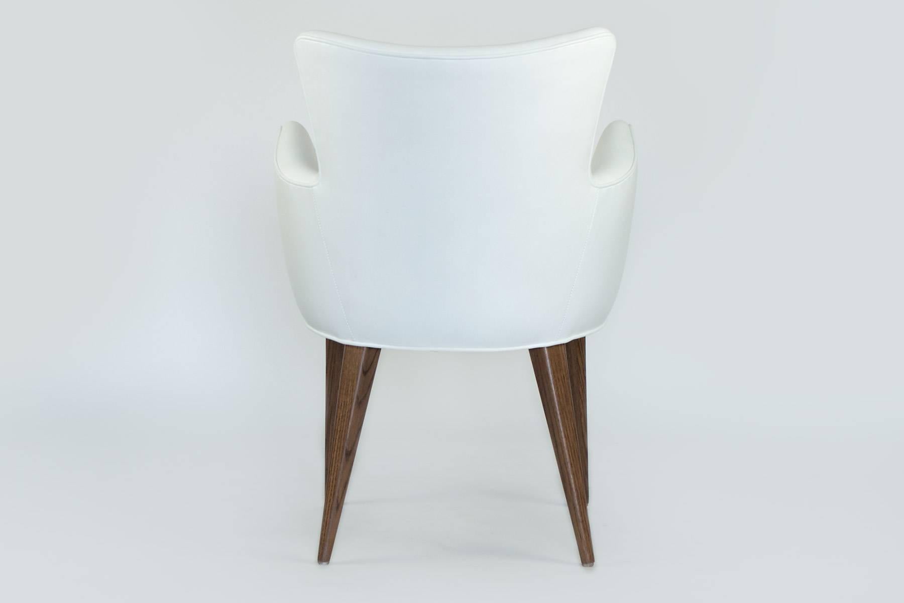 This stylish chair can stand alone as a side chair or is perfect in the dining room. It has modern lines, but the oak legs will sit well with any wood furnishings. The curved frame hugs you comfortably with the armrest being at a perfect height.