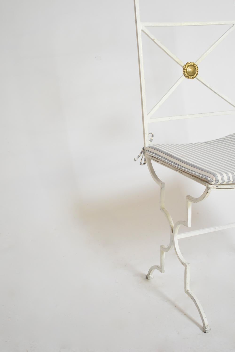 Set of 4 neoclassical white lacquered wrought iron chairs with bronze details in the back, in the style of Gilbert Poillerat. France, 1940s