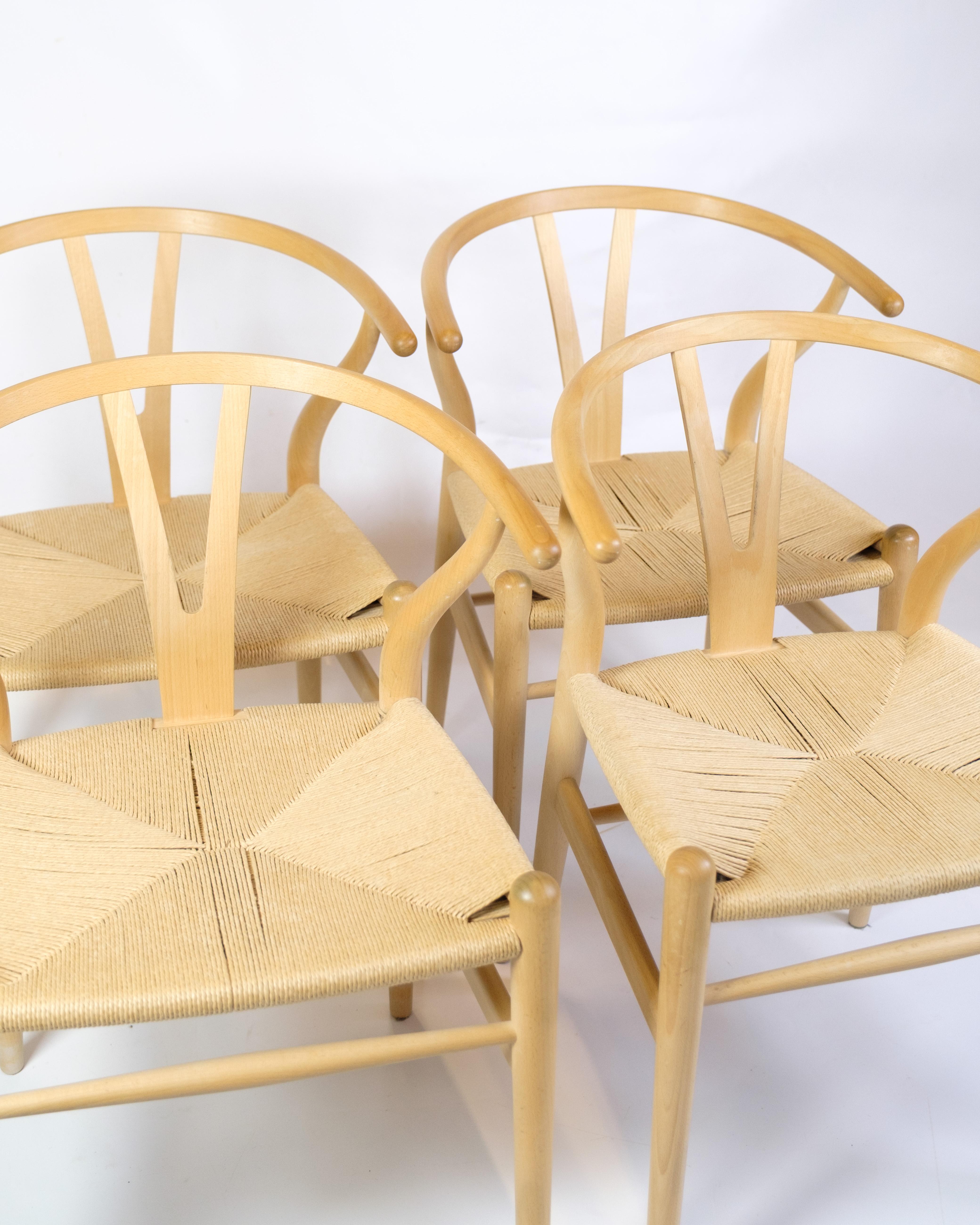 Ensemble de quatre chaises à oreilles, modèle CH24, conçu par Hans J. Wegner et produit par Carl Hansen & Son. Fabriqué en Beeche avec une assise en fil de papier tissé à la main. Hans J. Wegner (1914-2007) est un designer de meubles danois qui a