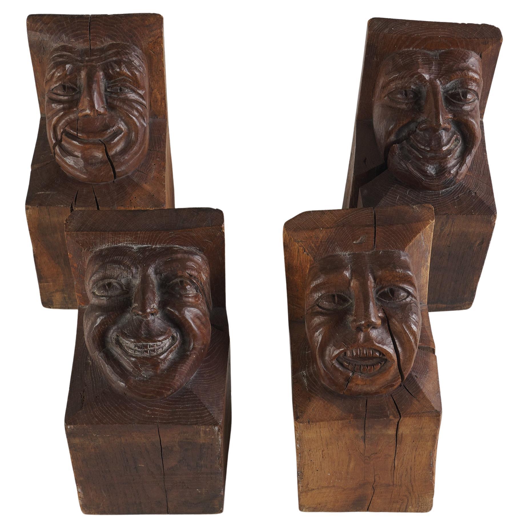 Satz von vier holzgeschnitzten Kragsteinen mit grotesken Gesichtern