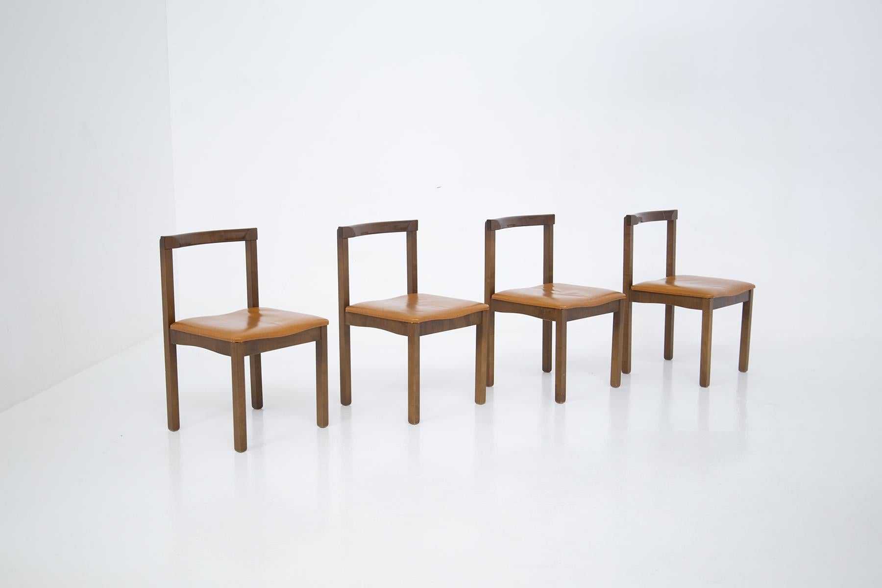 Set of four chairs by Vittorio Introini for manifattura Sormani 1950s. The chairs are made of wood for the frame and have a polished finish. The seat is upholstered in original brown leather of the time. The leather has no cracks or damage, only