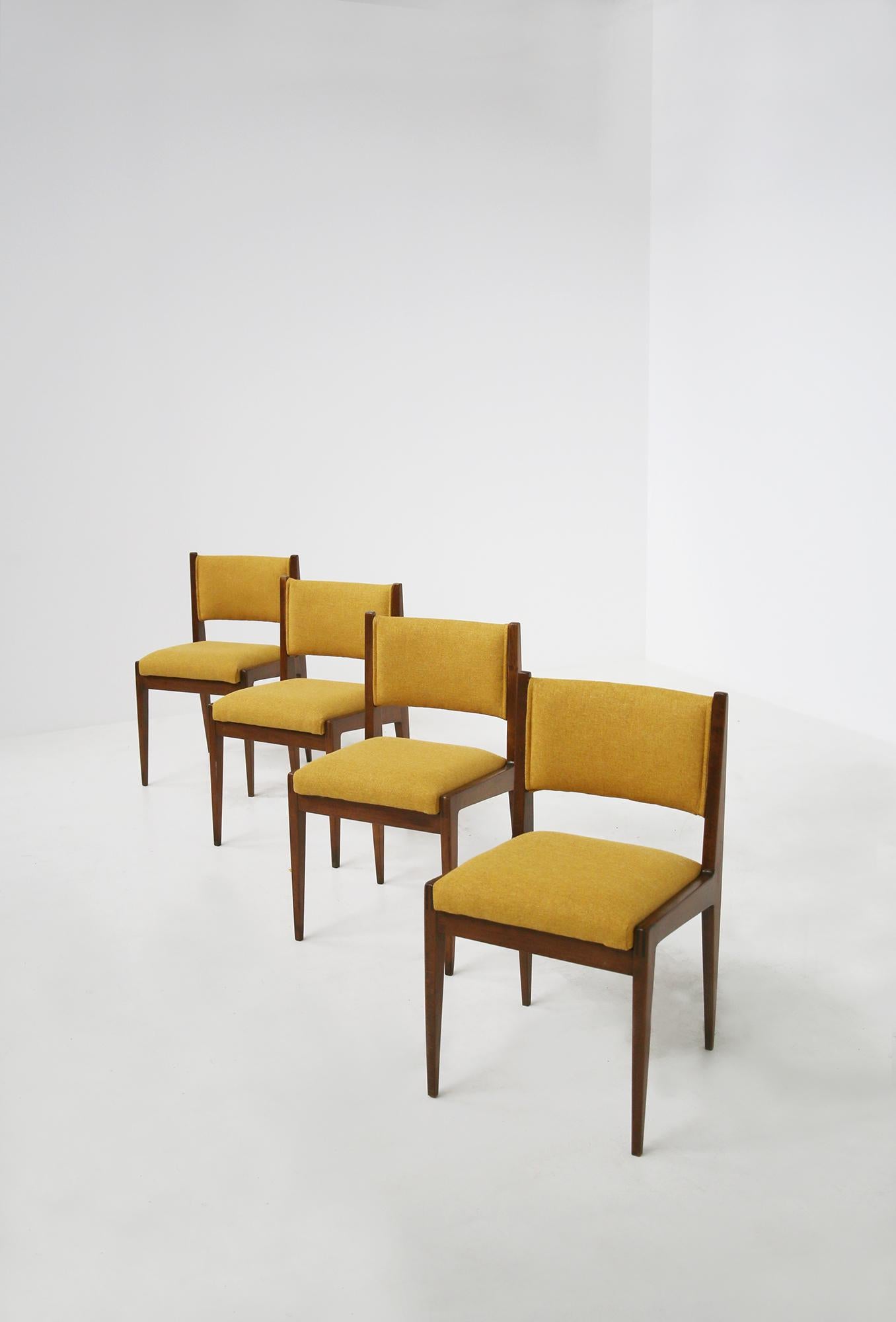 Set composed of four elegant Italian chairs designed by Gianfranco Frattini for Bottega Ghianda. The chairs are from 1970. The set is made of walnut wood with yellow Italian cotton padding. The peculiarity of the chairs is its sculpted line with