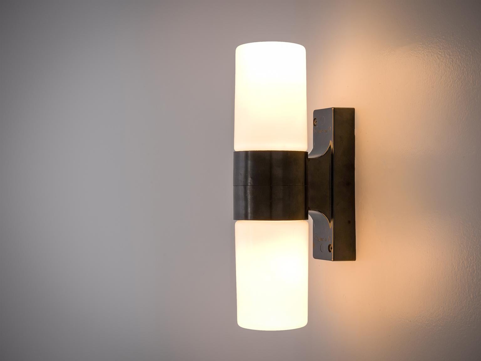 Wall lights, black bakelite and opaline light, Europe, 1970s.

This set of fourteen wall lights is Minimalist and features a black frame combined with white glass cylinders. The cylinder is attached with a rectangular block to the wall and holds the