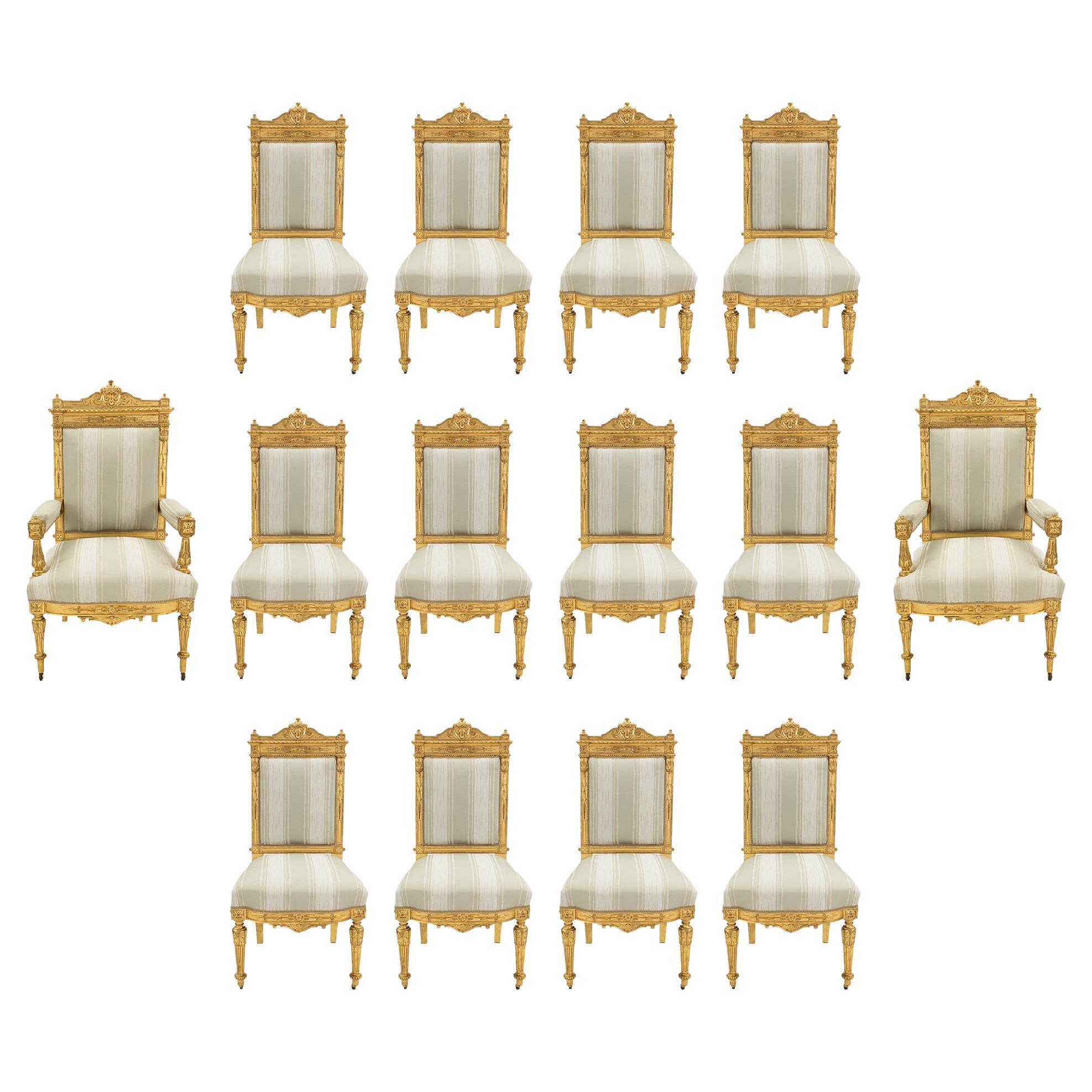 Satz von vierzehn französischen Louis-XVI-Esszimmerstühlen aus vergoldetem Holz, 19. Jh.