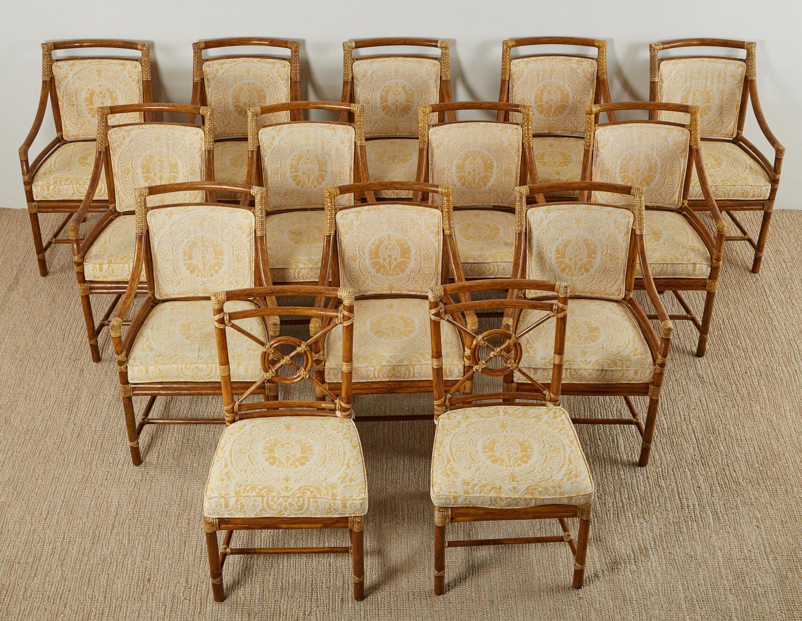 Grand set of fourteen genuine McGuire target back design dining armchairs featuring a bespoke Fortuny fabric upholstery. The set consists of twelve armchairs and two side chairs the later having an exposed back and matching seat cushion 20.5 inches