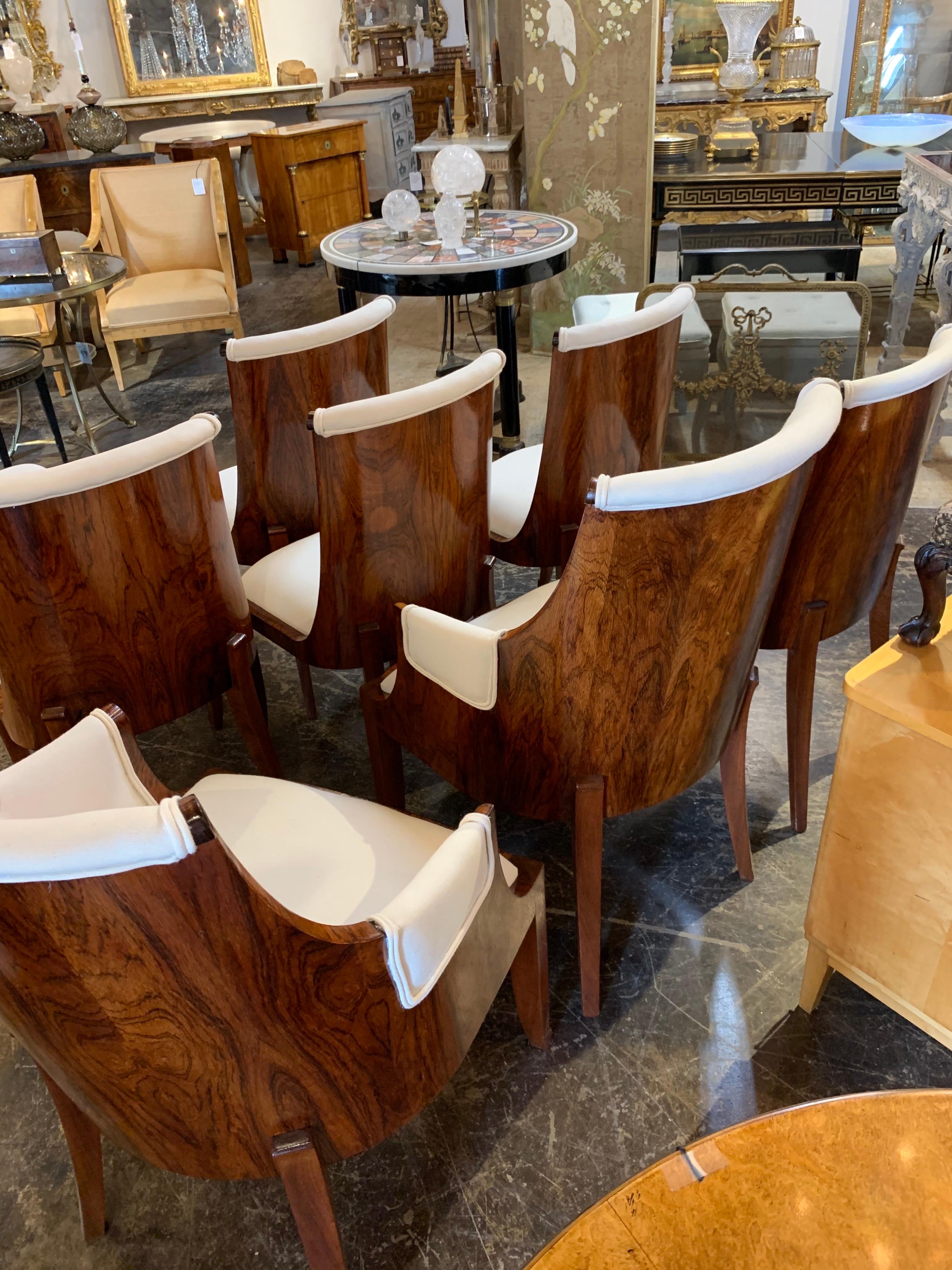 Exquisite set of French Art Deco rosewood dining chairs. Very fine finish on these and upholstered in a crème colored fabric. The set includes 2 armchairs and 6 side chairs. Exceptional quality and truly elegant!