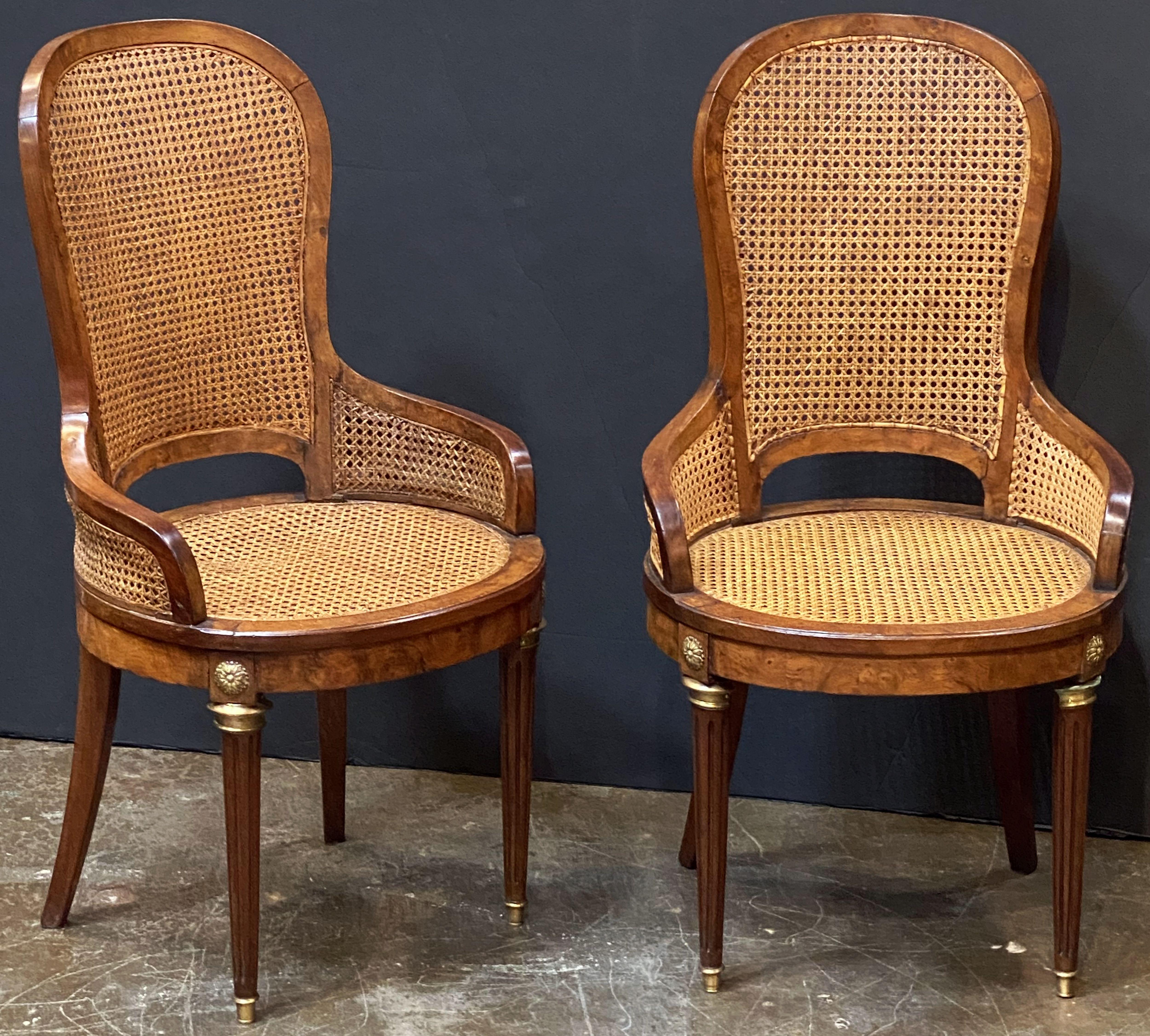 A fine set of caned Bergère dining chairs of walnut from France, including two arm chairs and four side chairs.
  