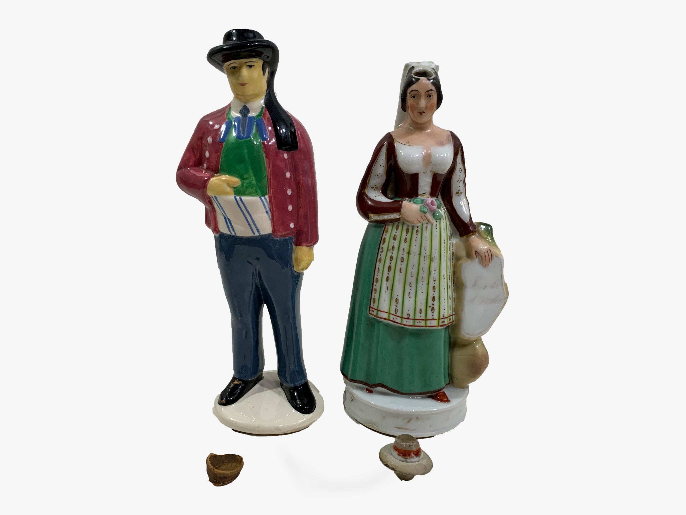 A set of 2 Vintage Henriot Quimper Handpainted Liquor Bottle Figurine Couple
Made from polychrome enameled porcelain with a cork stopper.
A figural man and woman in traditional European garb. He wears a black hat, red jacket and blue and green suit;