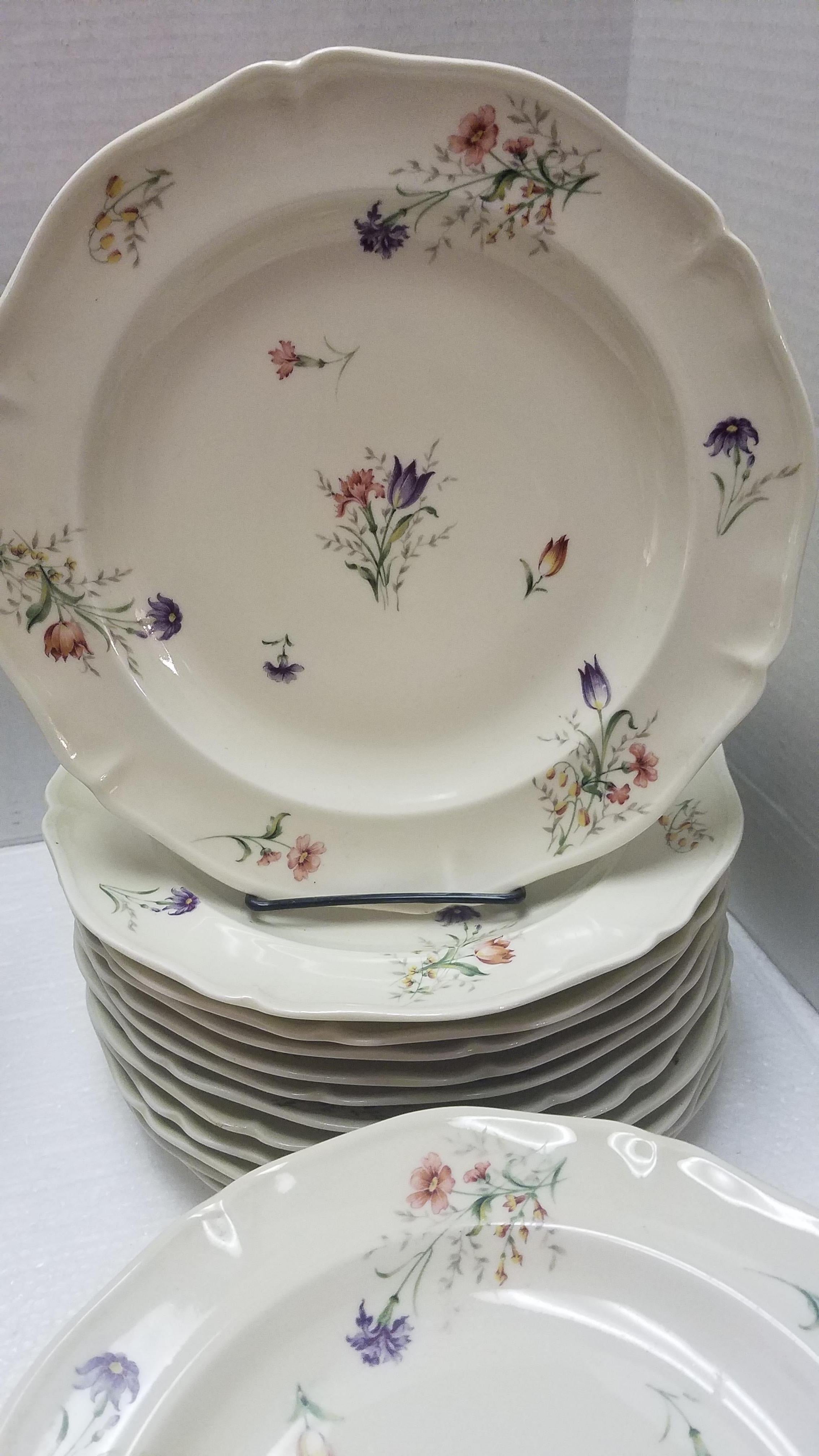 Set of vintage French Limoges dinnerware. See makers marks on the back of the pieces. Purchased from the Brittany region of France. Beautifully hand painted with scattered flowers in shades of pink yellow and purple with green foliage. The set