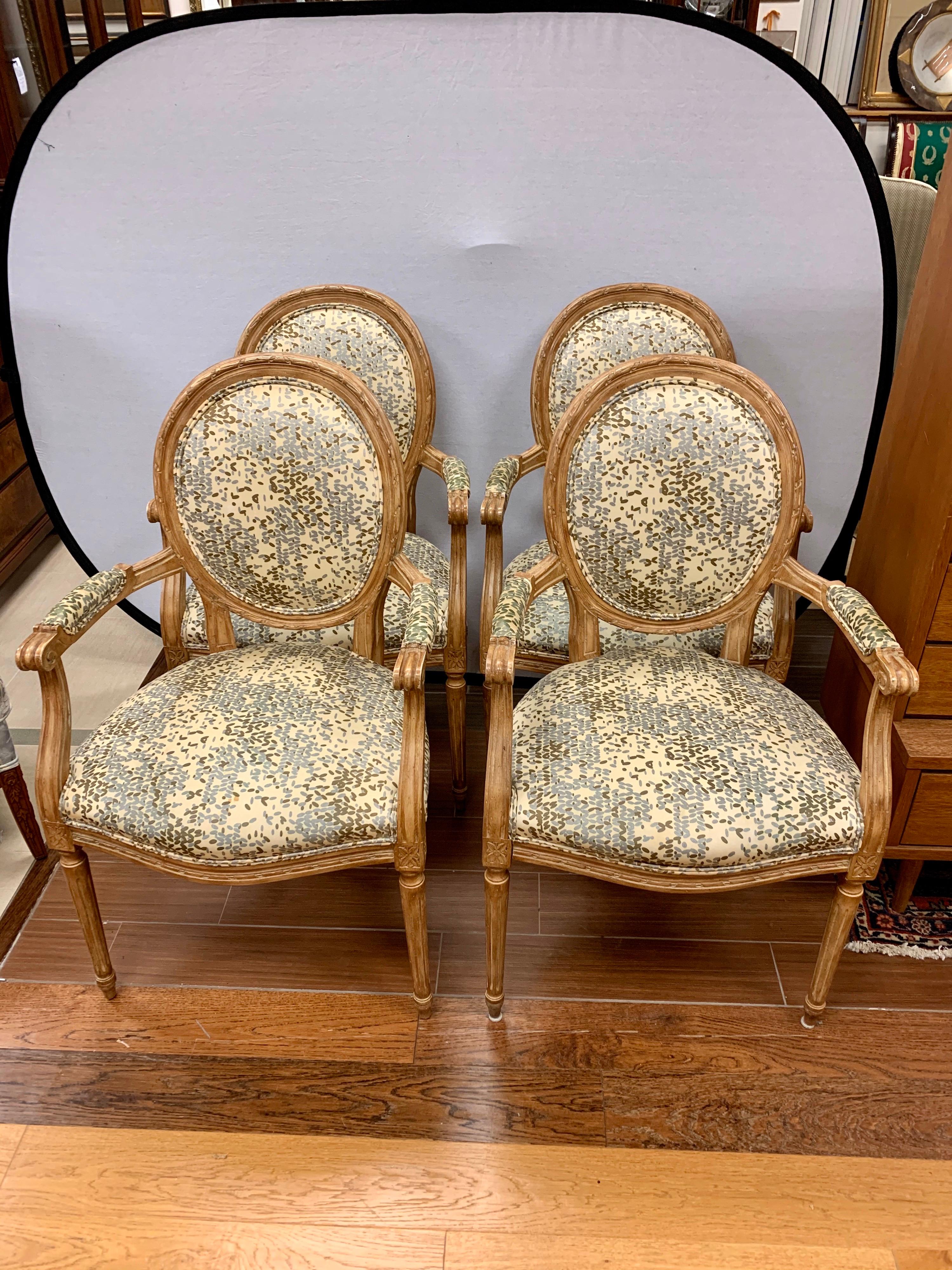 Elegant and ornate set of four matching Louis XVI oval back armchairs with Kravet fabric. Upholstered on the arms, seat, and backrest. All dimensions are below.