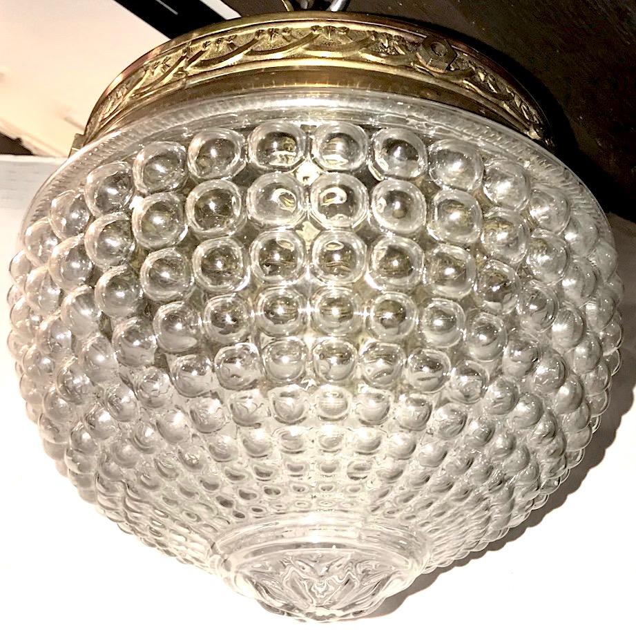 Juego de cinco lámparas colgantes de cristal moldeado de estilo neoclásico francés de hacia 1950, con luz interior. Se venden por unidades.

Medidas:
Diámetro: 9
Altura del cuerpo: 9