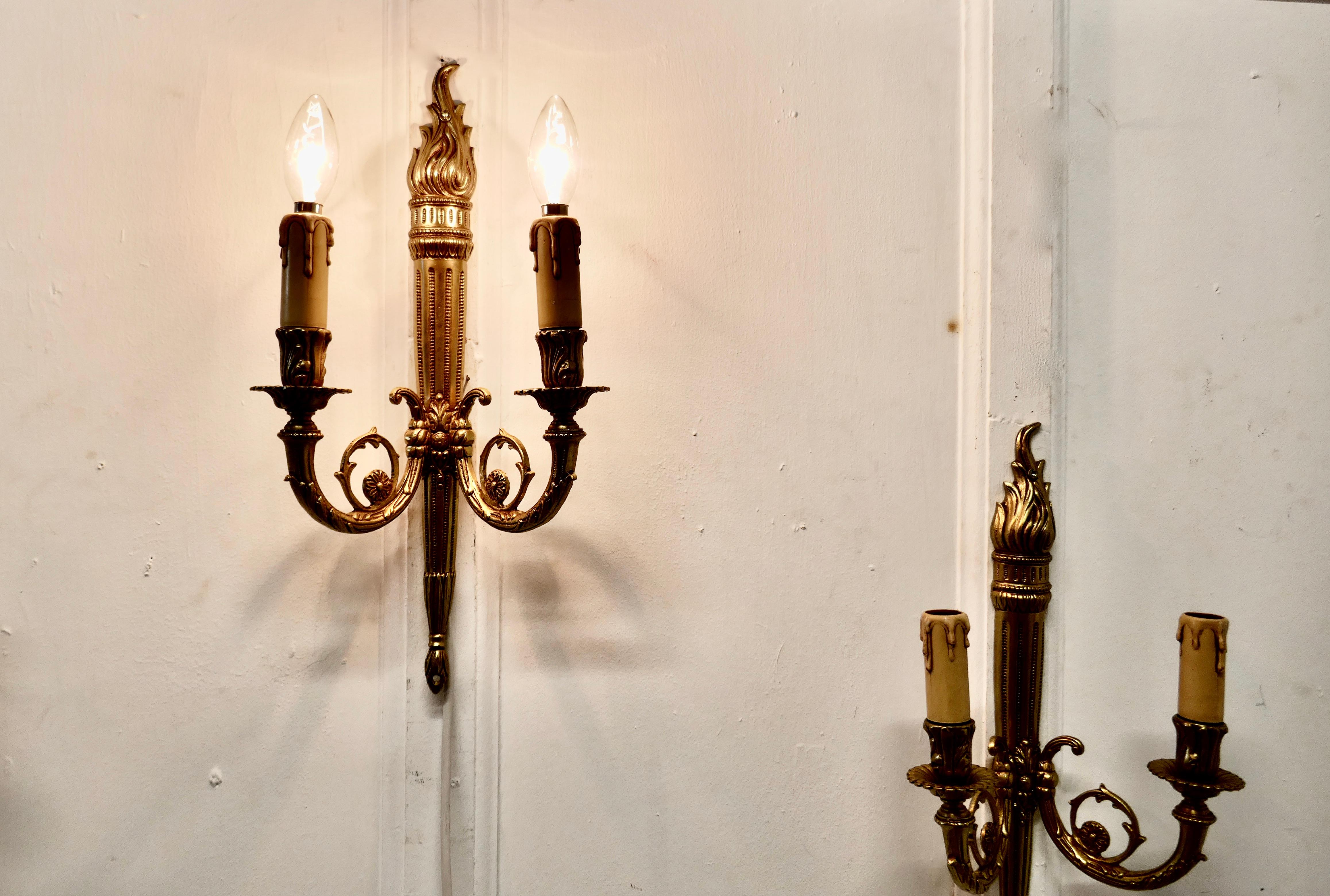 Set of French neoclassical large brass twin wall lights


A very handsome set of large heavy brass wall lights, the lights are in the classical style of a lighted torch with acanthus leaf scroll branches
Each light has 2 branches each with a