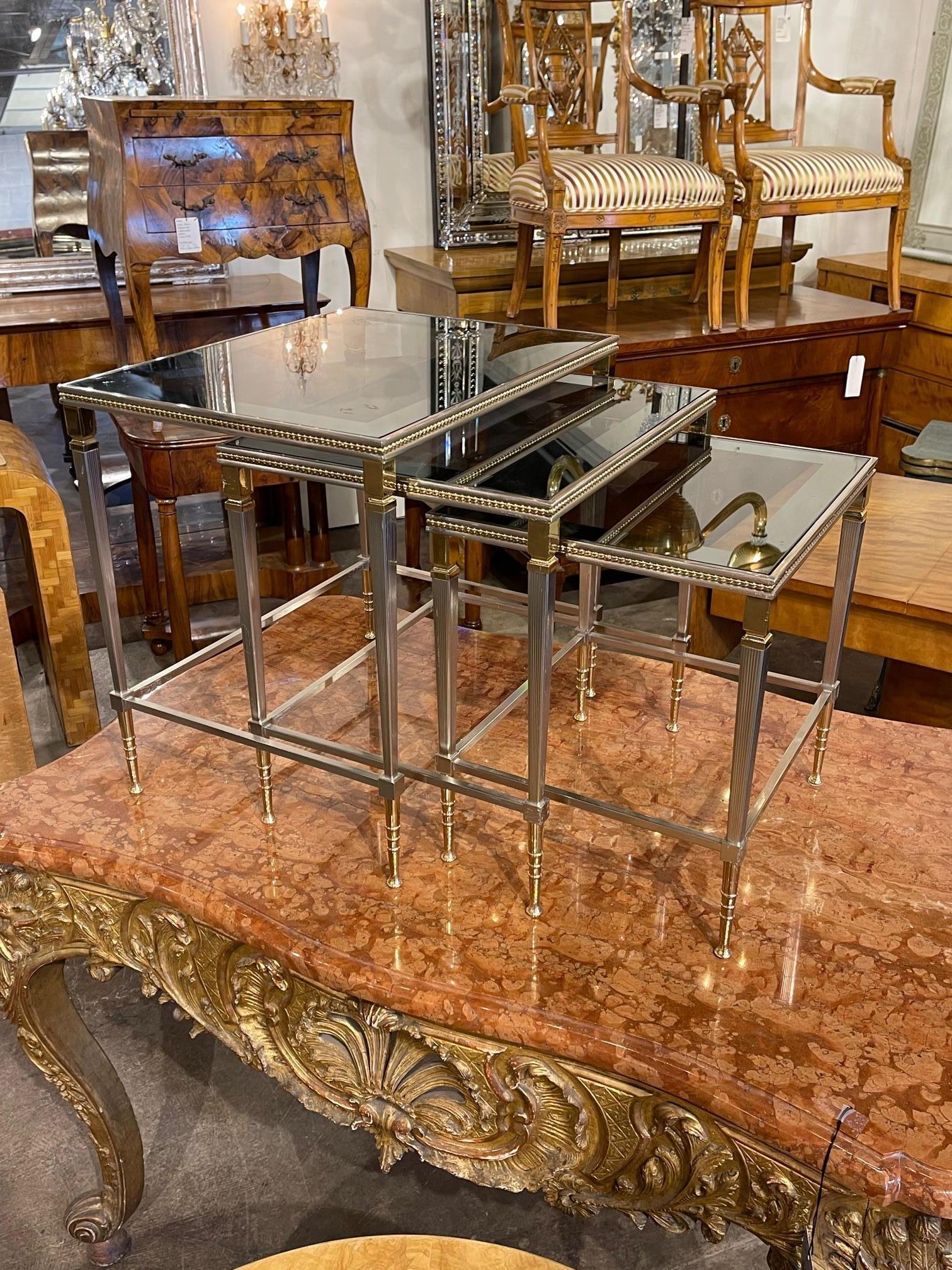 Very fine set of French Jansen style polished steel and brass nesting tables. A quality set with lots of pretty details. Beautiful!