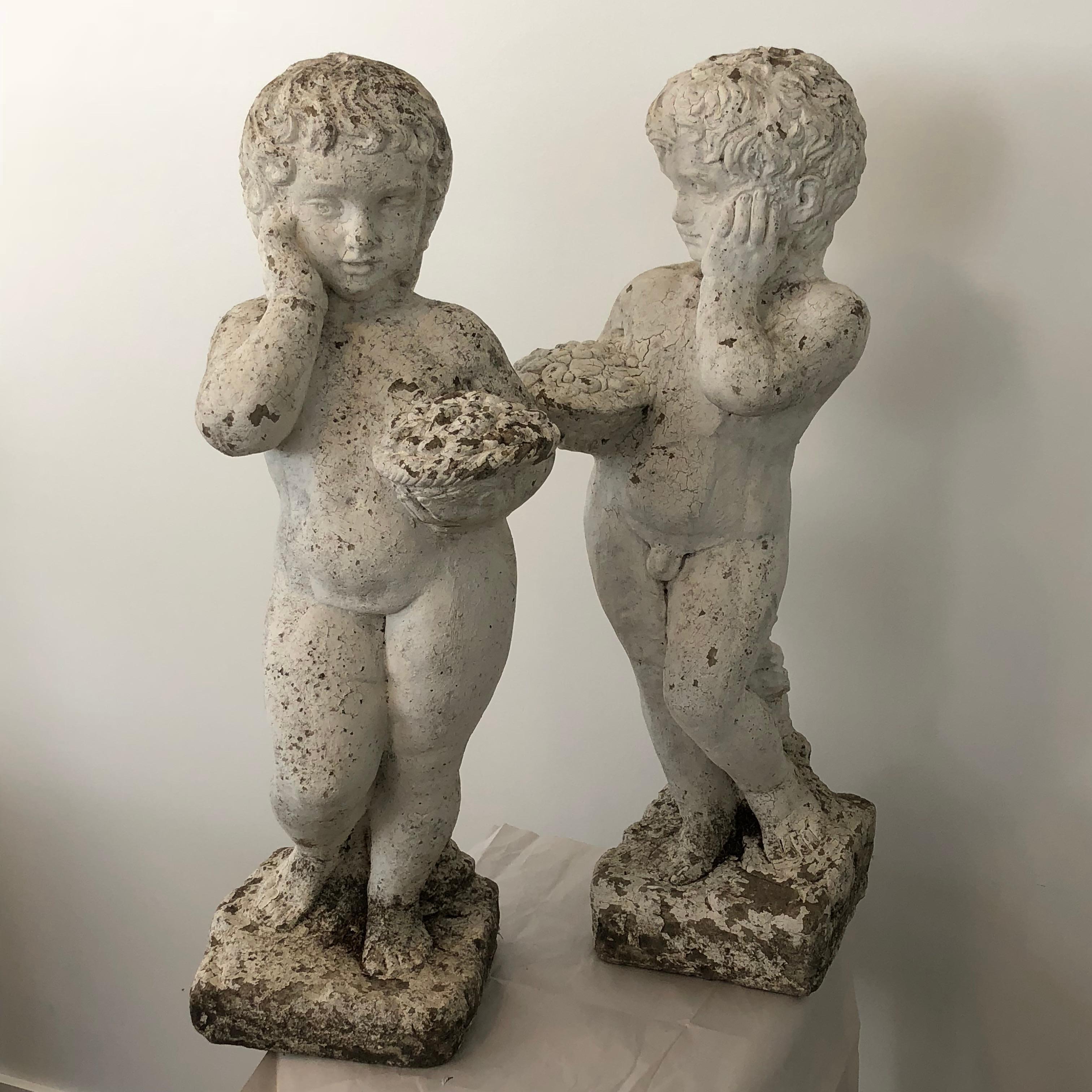 Charming set of male and female stone Putti from France with fabulously expressive coy features and perfect patina. Suitable for interior or exterior settings.