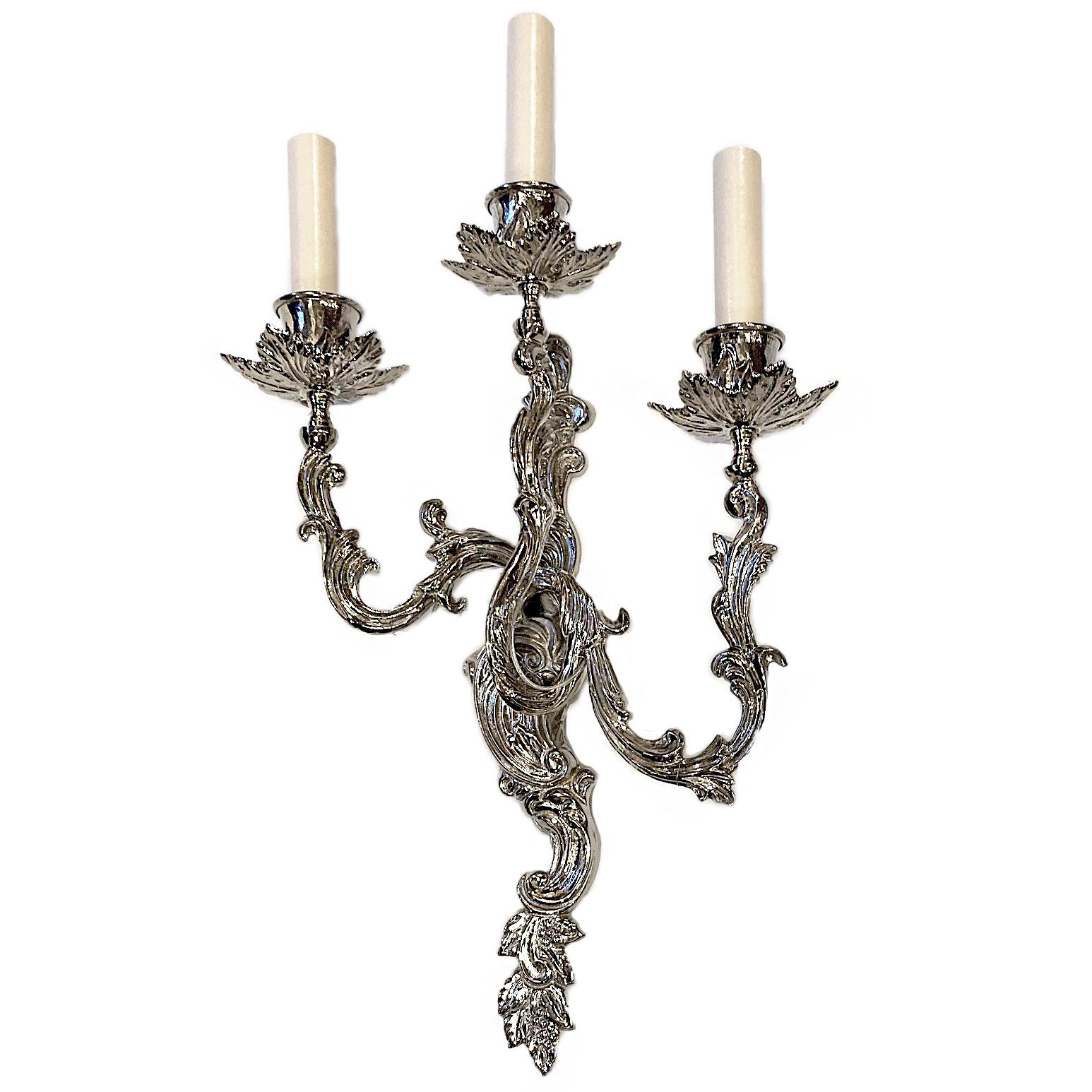 A set of four French circa 1950s Louis XV style three-light sconces with silver plated finish.

Measurements:
Height 20
